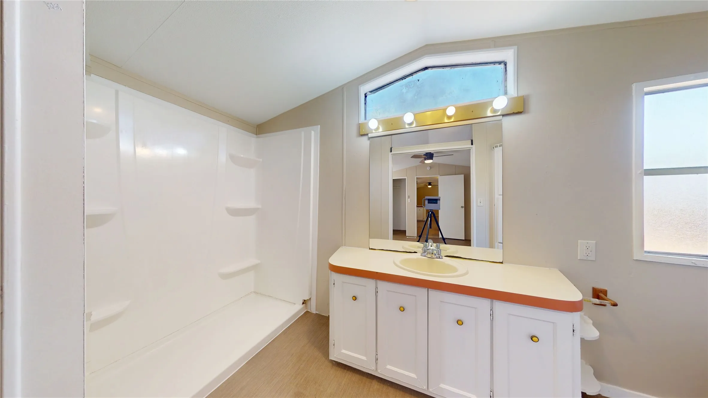 Large vanity with an integrated sink, wall-mounted mirror, and vanity lighting
