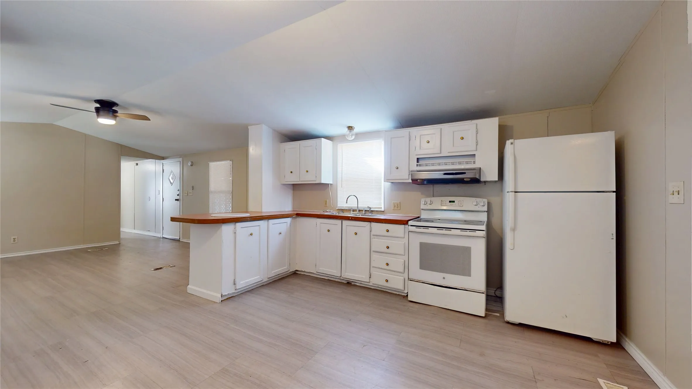 Kitchen featuring white cabinetry, wood-finish countertops, and an included refrigerator and range