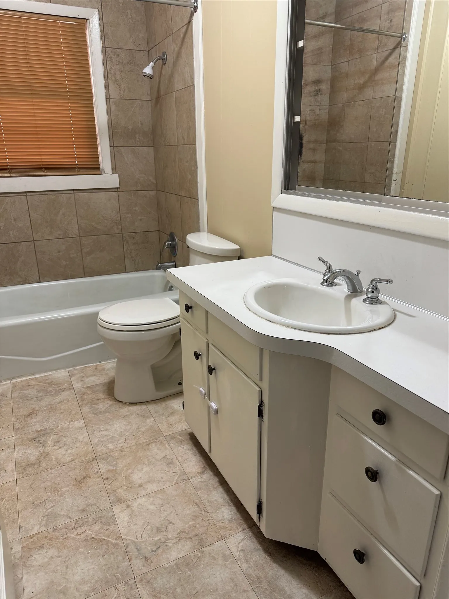 Full bathroom with vanity, tiled shower / bath, tile patterned flooring, and toilet