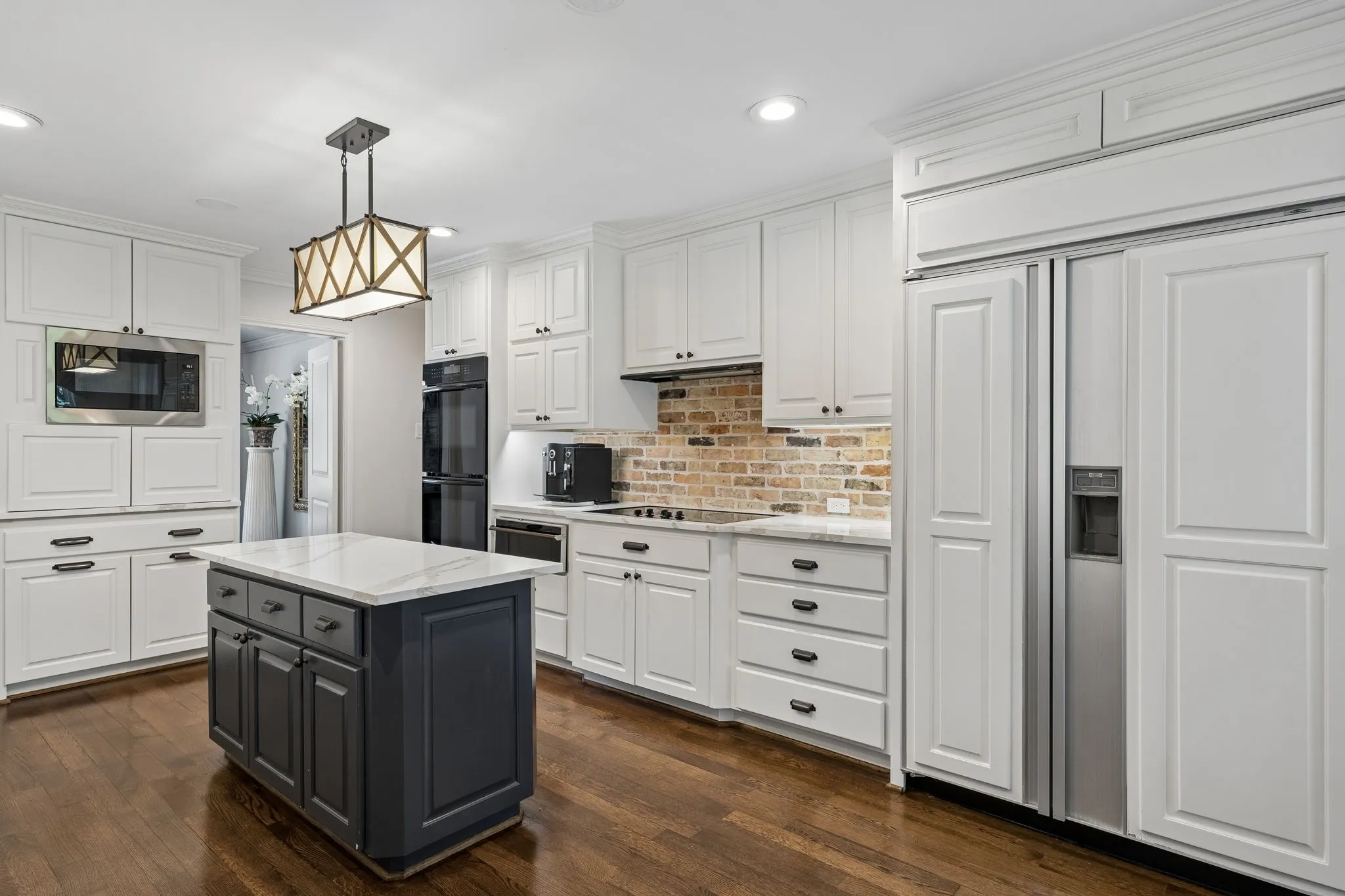 Kitchen with Quartz countertops and brick backslash.  Built in Subzero Refrigerator.