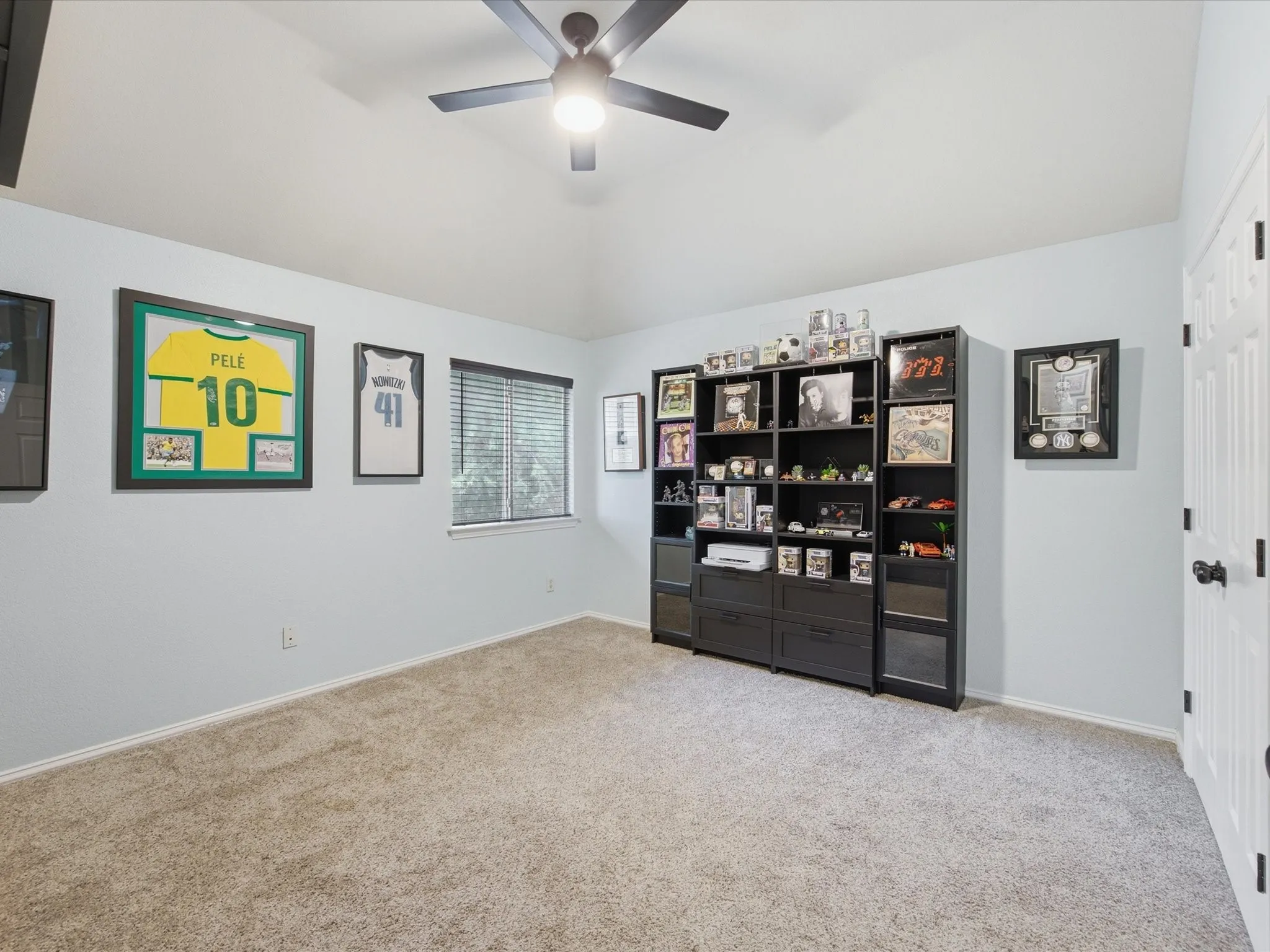Carpeted room featuring a ceiling fan with integrated lighting, and a window with blinds
