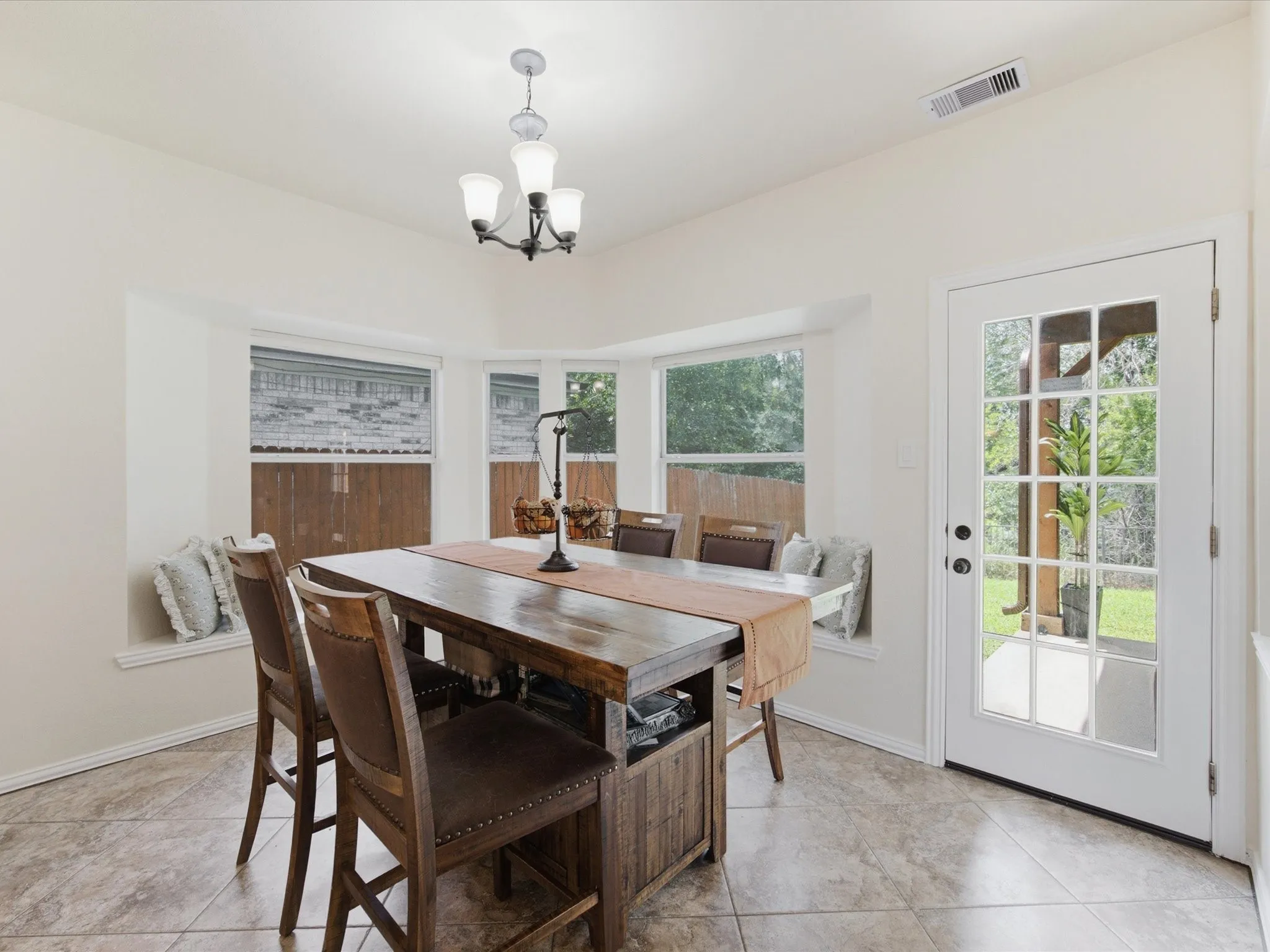 Dining area featuring a bay window with a built-in bench, a full-lite exterior door, and tile flooring