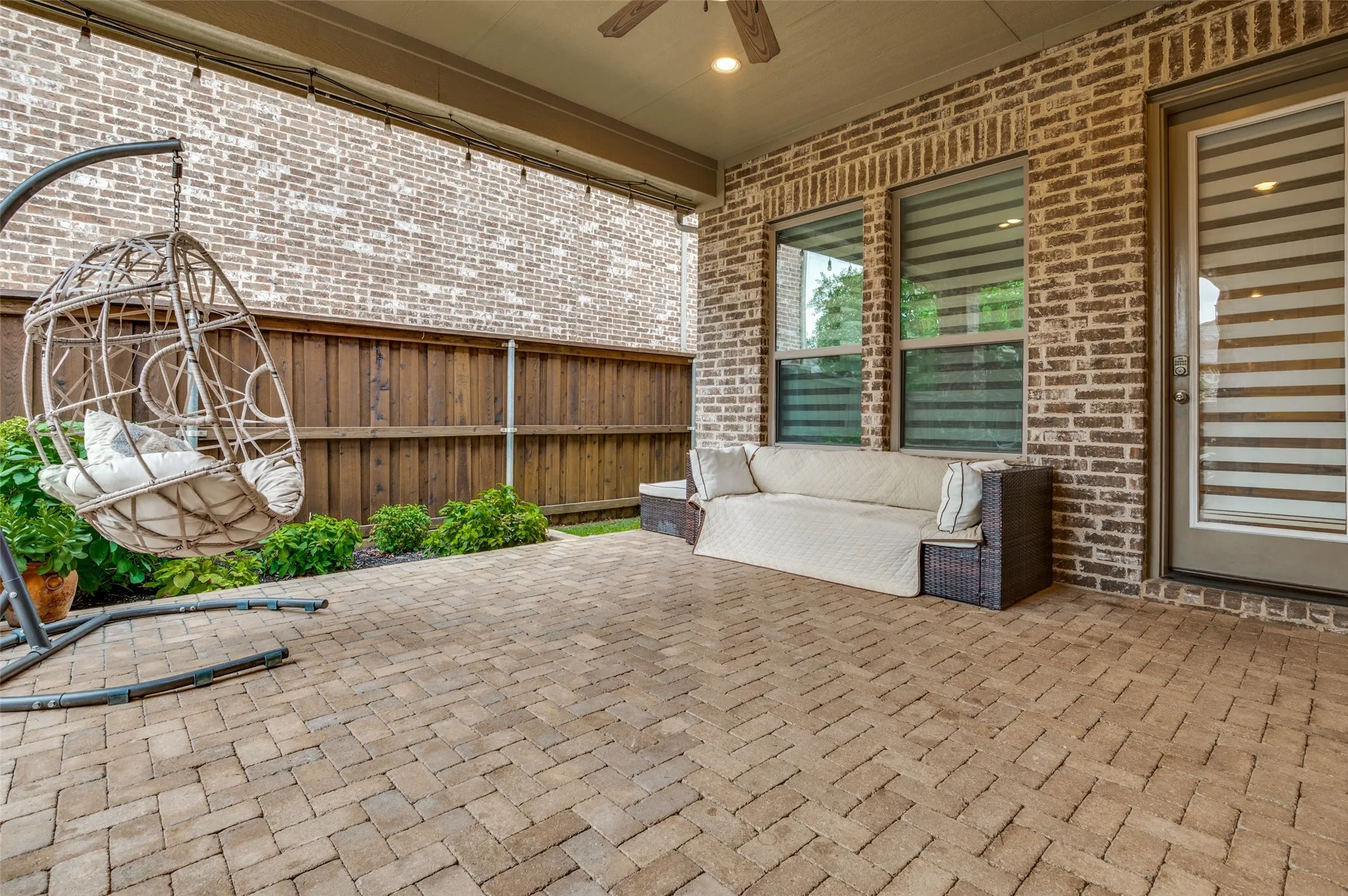 Expansive covered patio featuring brick pavers, a ceiling fan, and recessed lighting