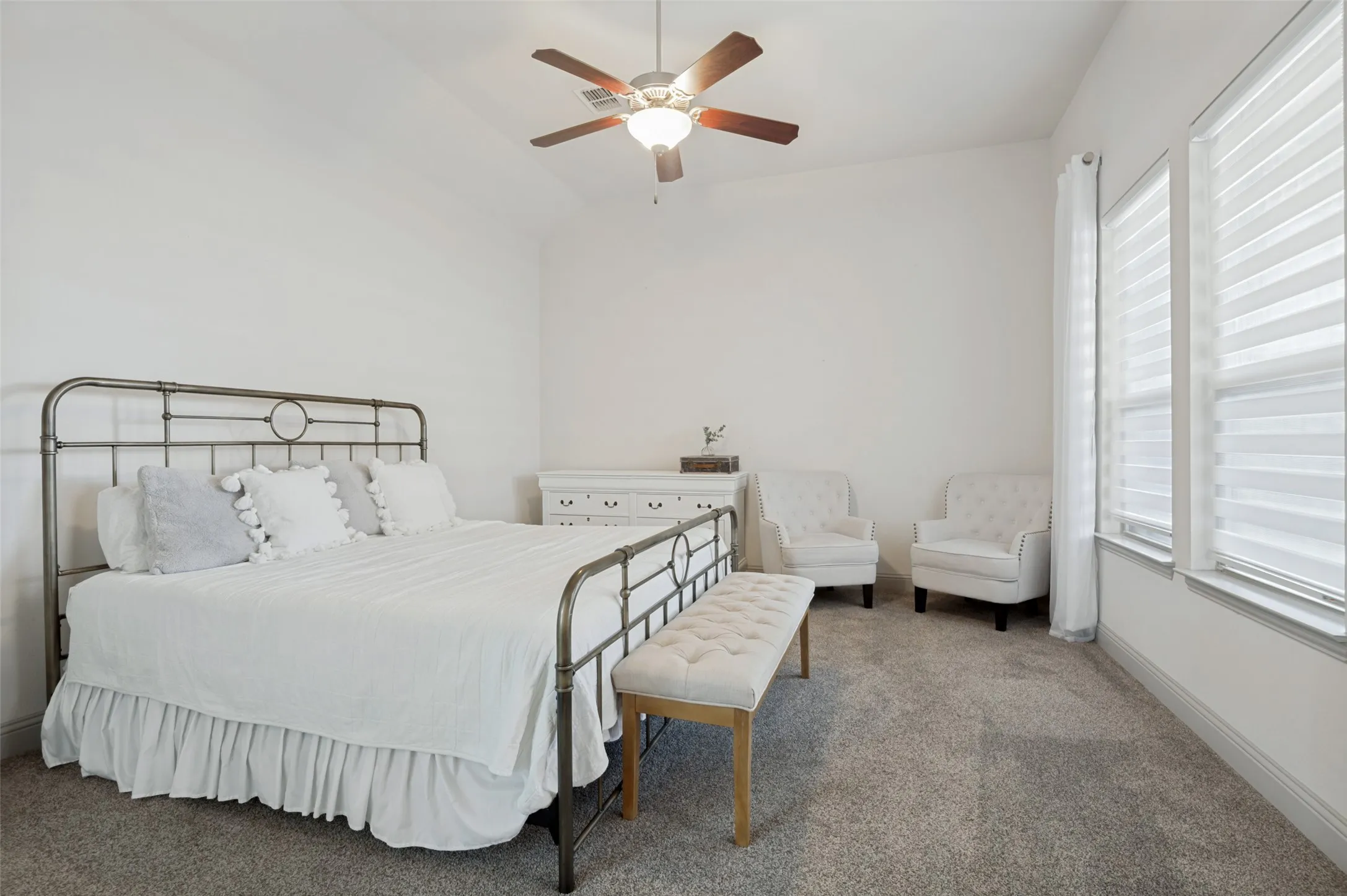 Carpeted bedroom featuring a vaulted ceiling with a ceiling fan