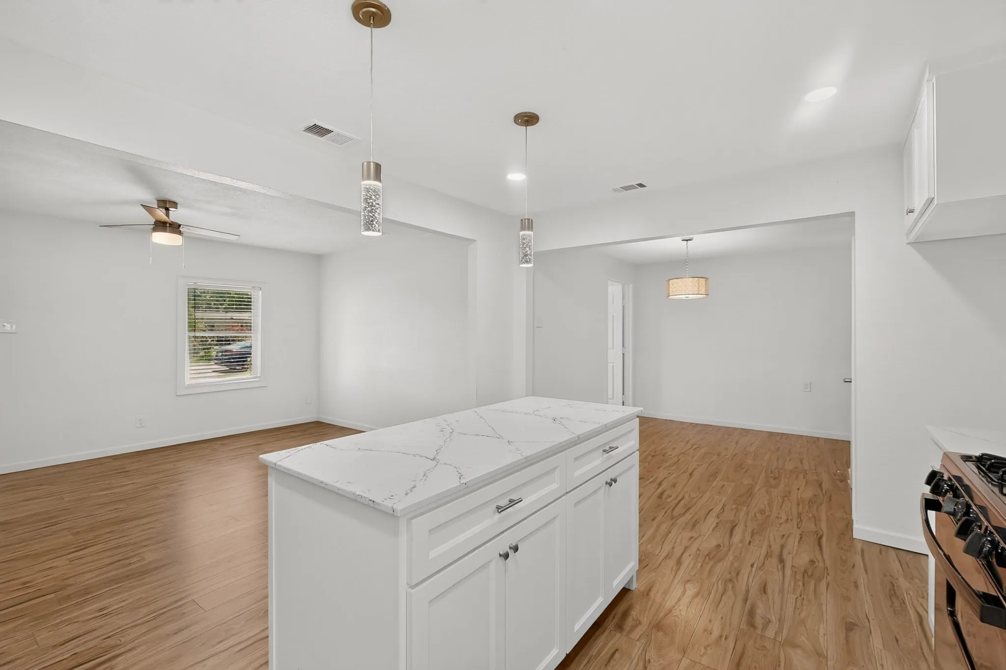 Kitchen island featuring a veined countertop and white cabinetry