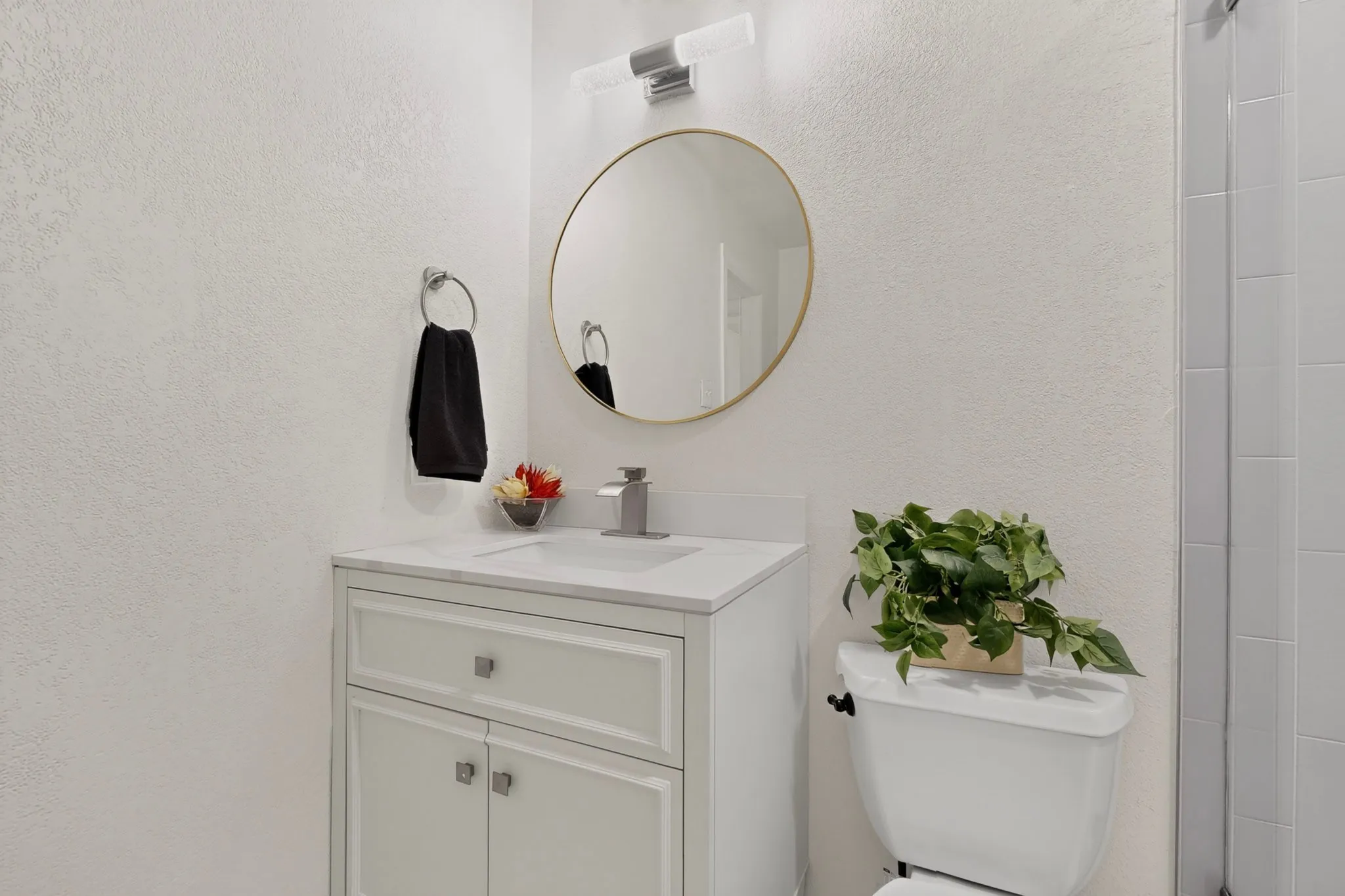 White vanity with a rectangular sink, single-handle faucet, and integrated countertop