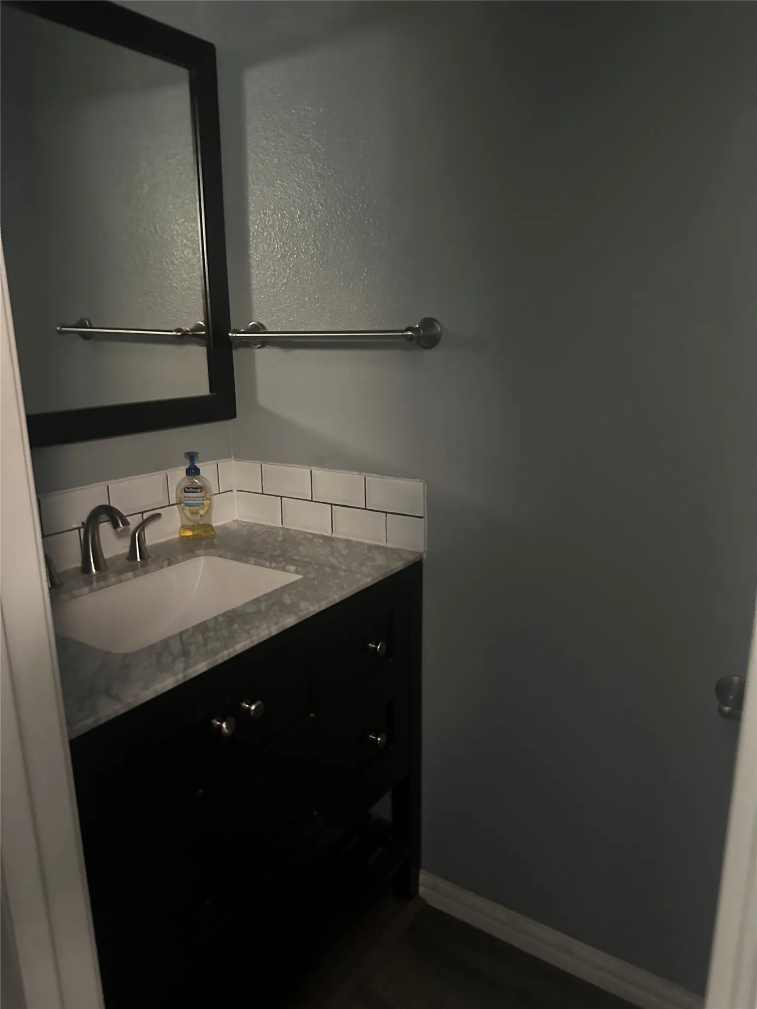 Bathroom vanity featuring a dark wood-finish cabinet, integrated sink, and stone-finish countertop