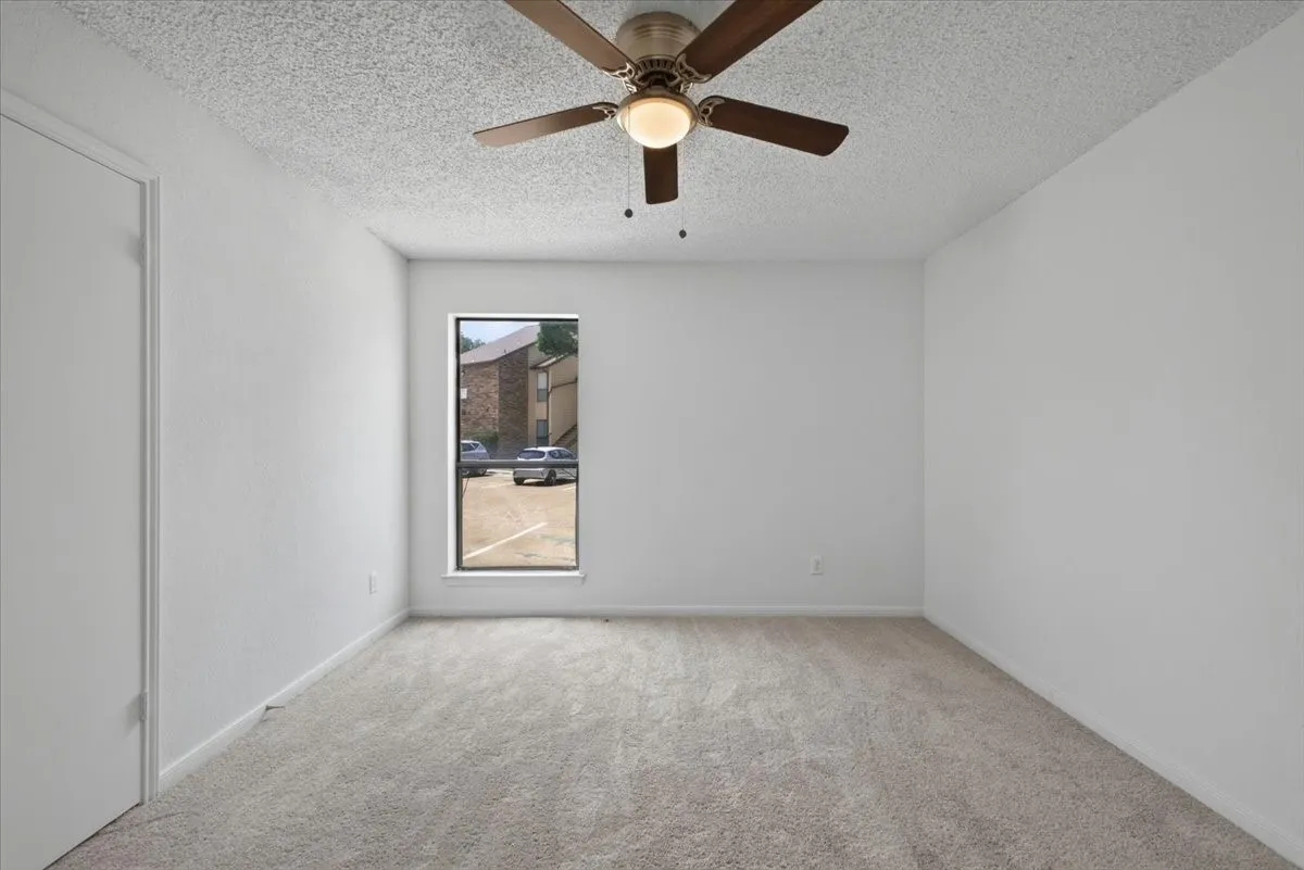 Carpeted bedroom with a ceiling fan, a single window, and a white closet door