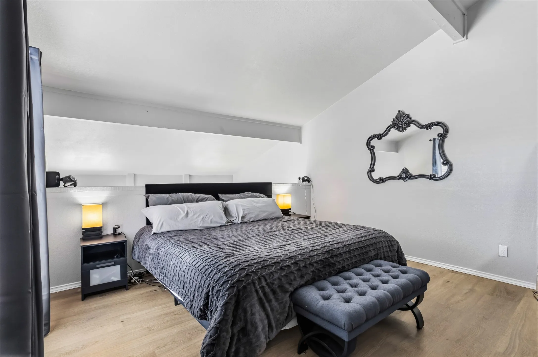 Spacious room featuring vaulted ceilings and wood-finish flooring