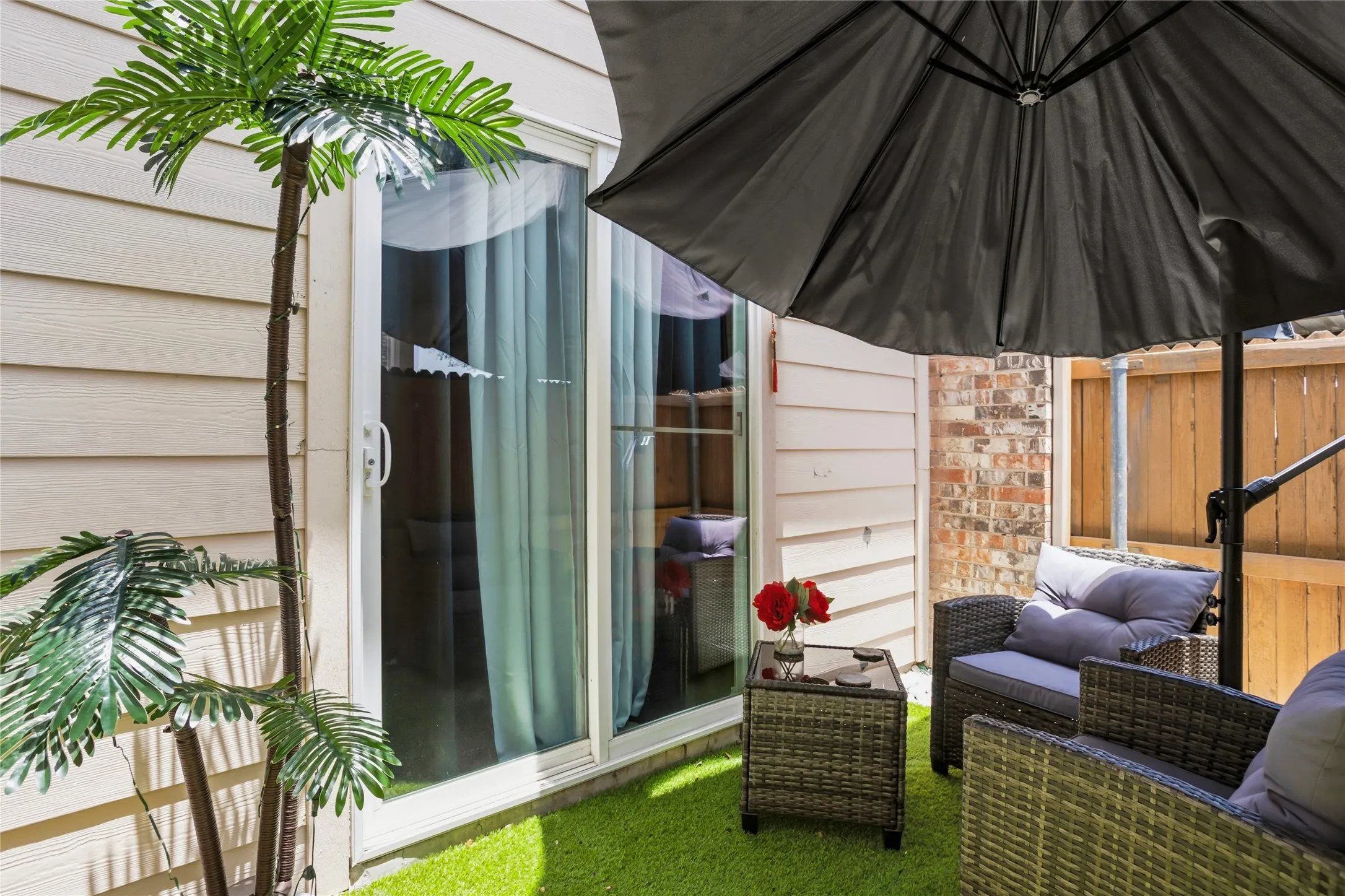 Fenced in patio area with access through sliding doors to the kitchen. Cute set up with cozy
chairs and a umbrella for shade!