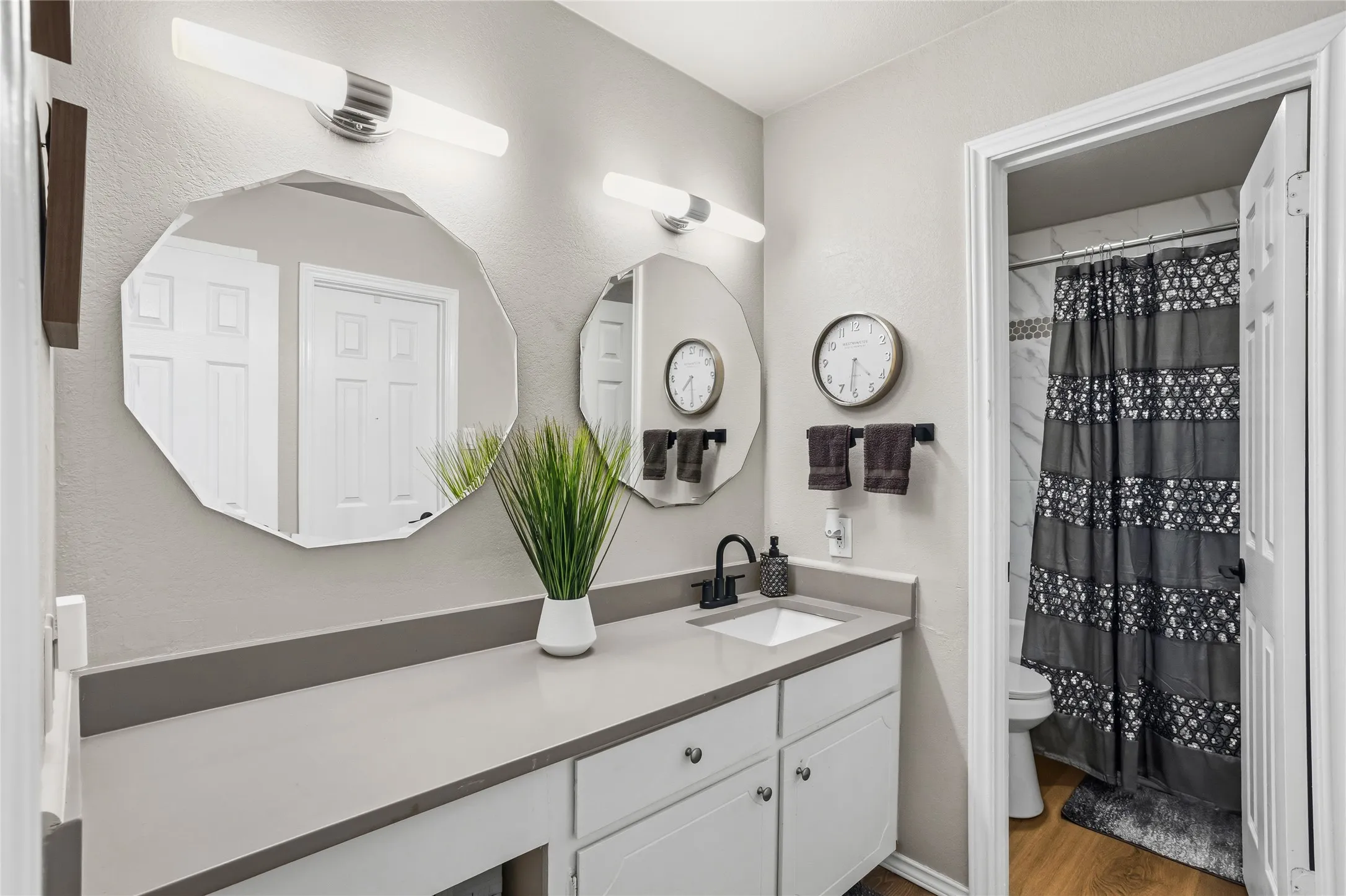Double vanity featuring a light gray countertop with an integrated sink and matte black faucet