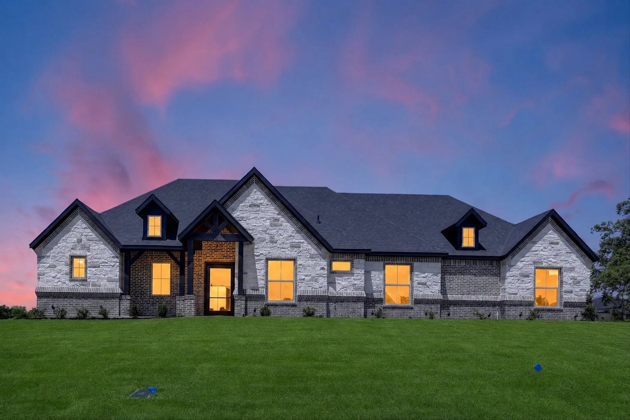 Stone and brick facade with a dark shingle roof