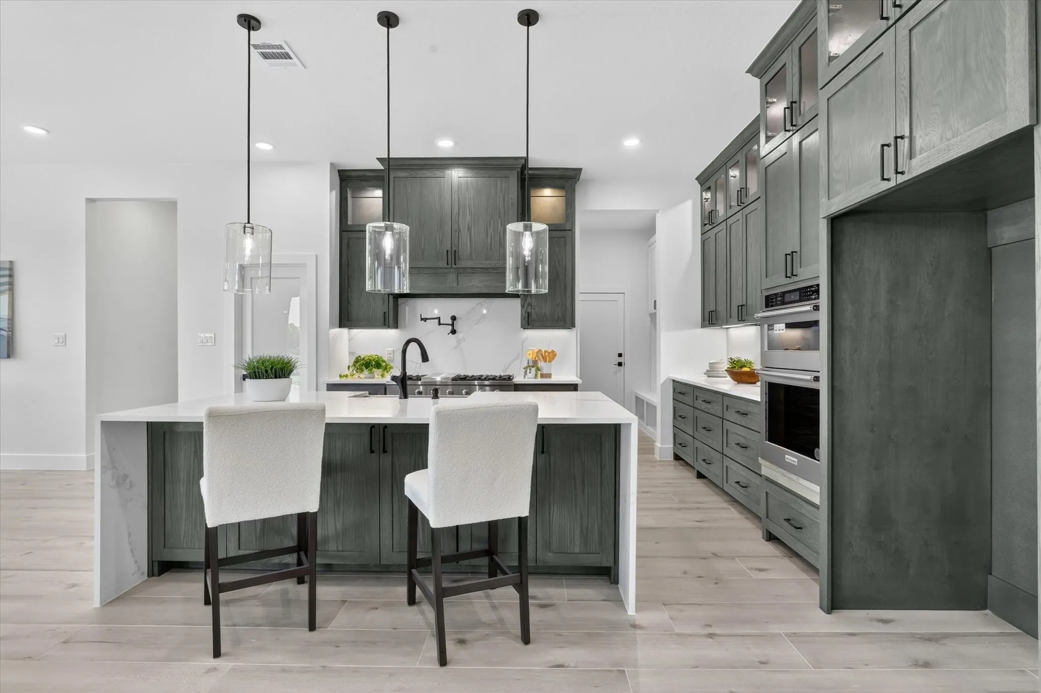 Kitchen featuring light wood-finish flooring and a central island with a waterfall countertop