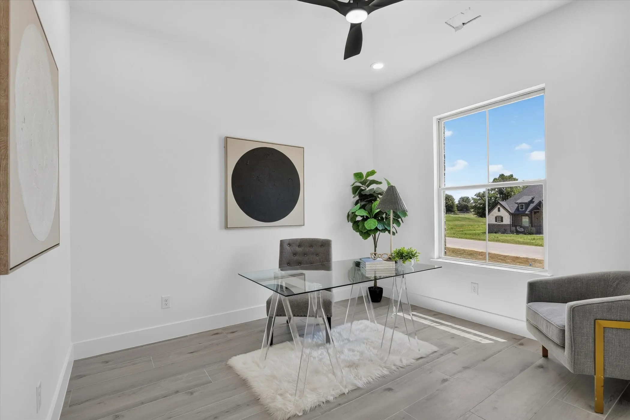 Bright room featuring a large window, light wood-finish flooring, recessed lighting, and a ceiling fan