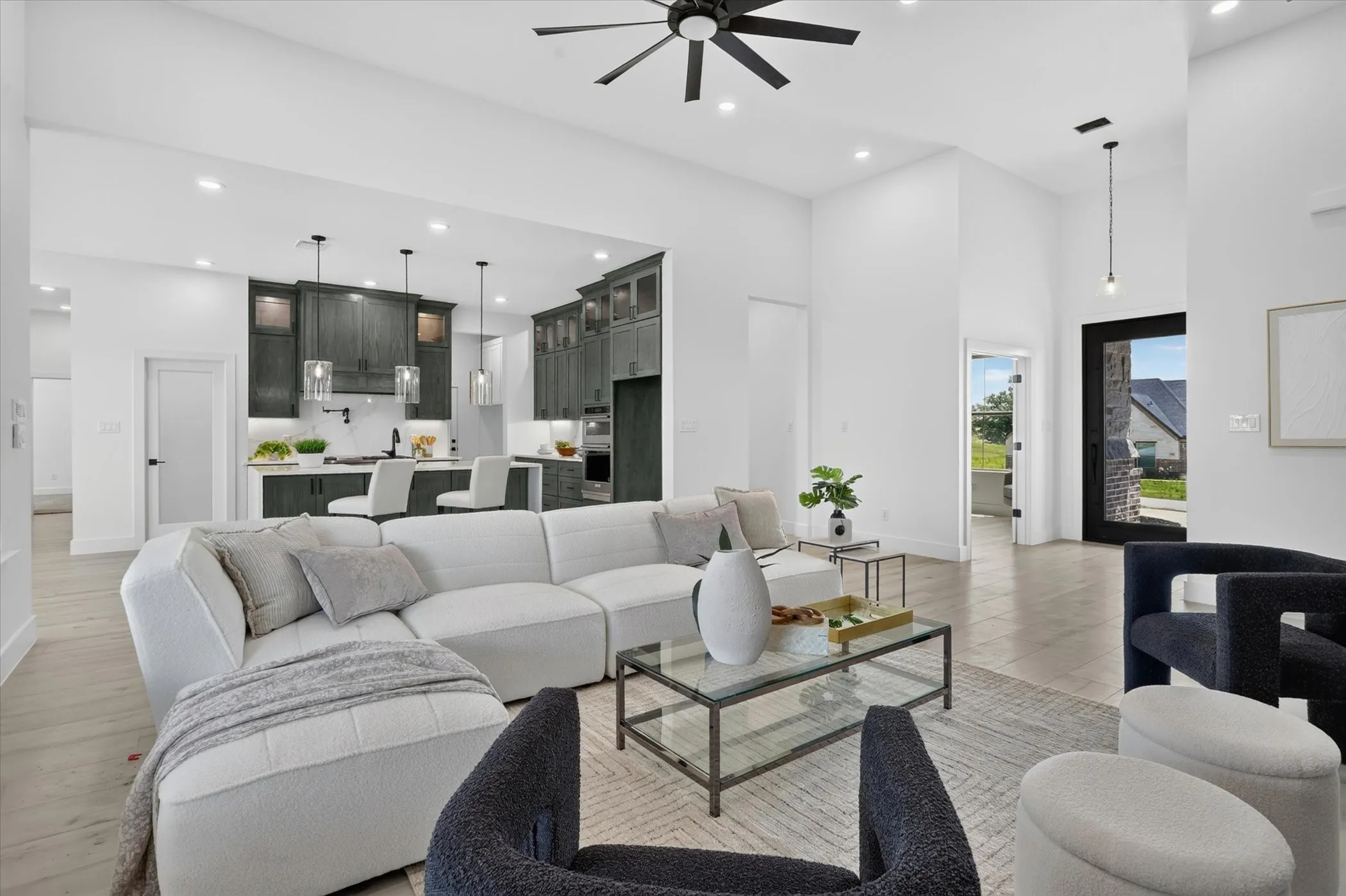 Open-concept living area featuring high ceilings, wood-finish flooring, and recessed lighting