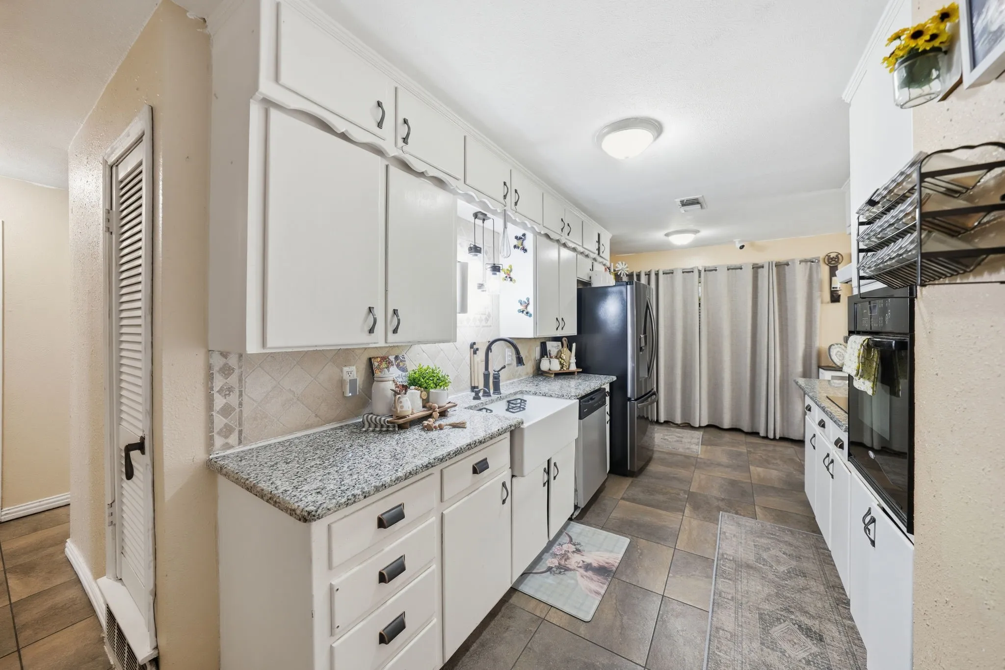 Kitchen featuring white cabinetry, granite-finish countertops, and an integrated stainless steel dishwasher