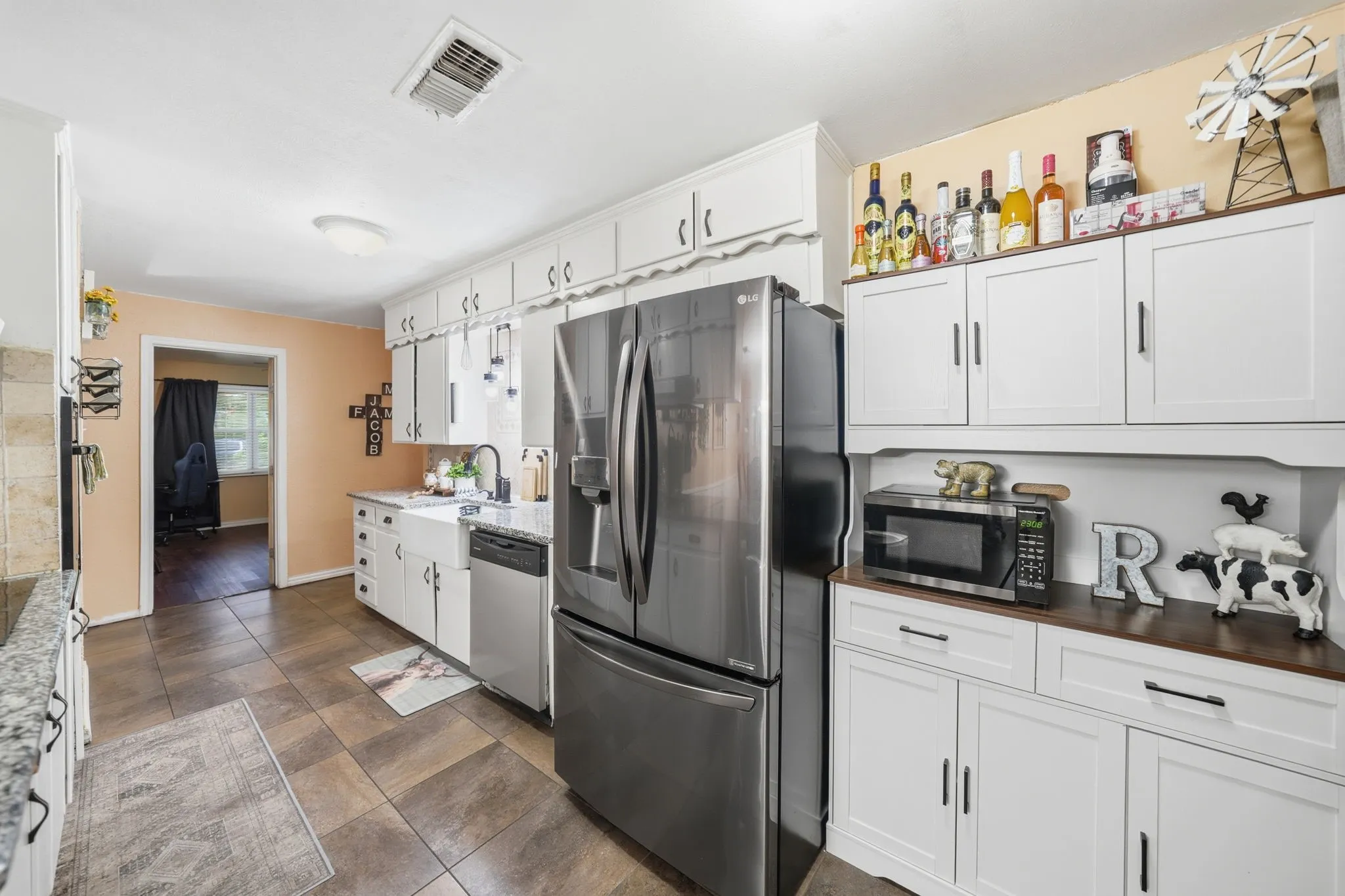 Kitchen featuring white shaker-style cabinetry, granite countertops, and stainless steel appliances