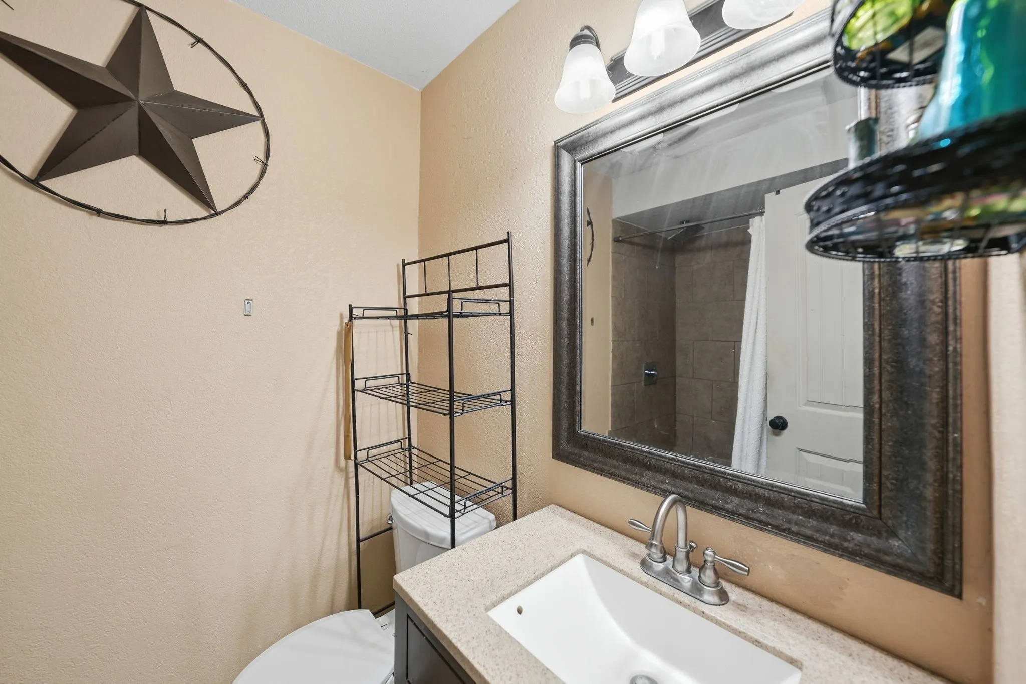 Bathroom vanity with an integrated sink, dual-handle faucet, and framed wall mirror