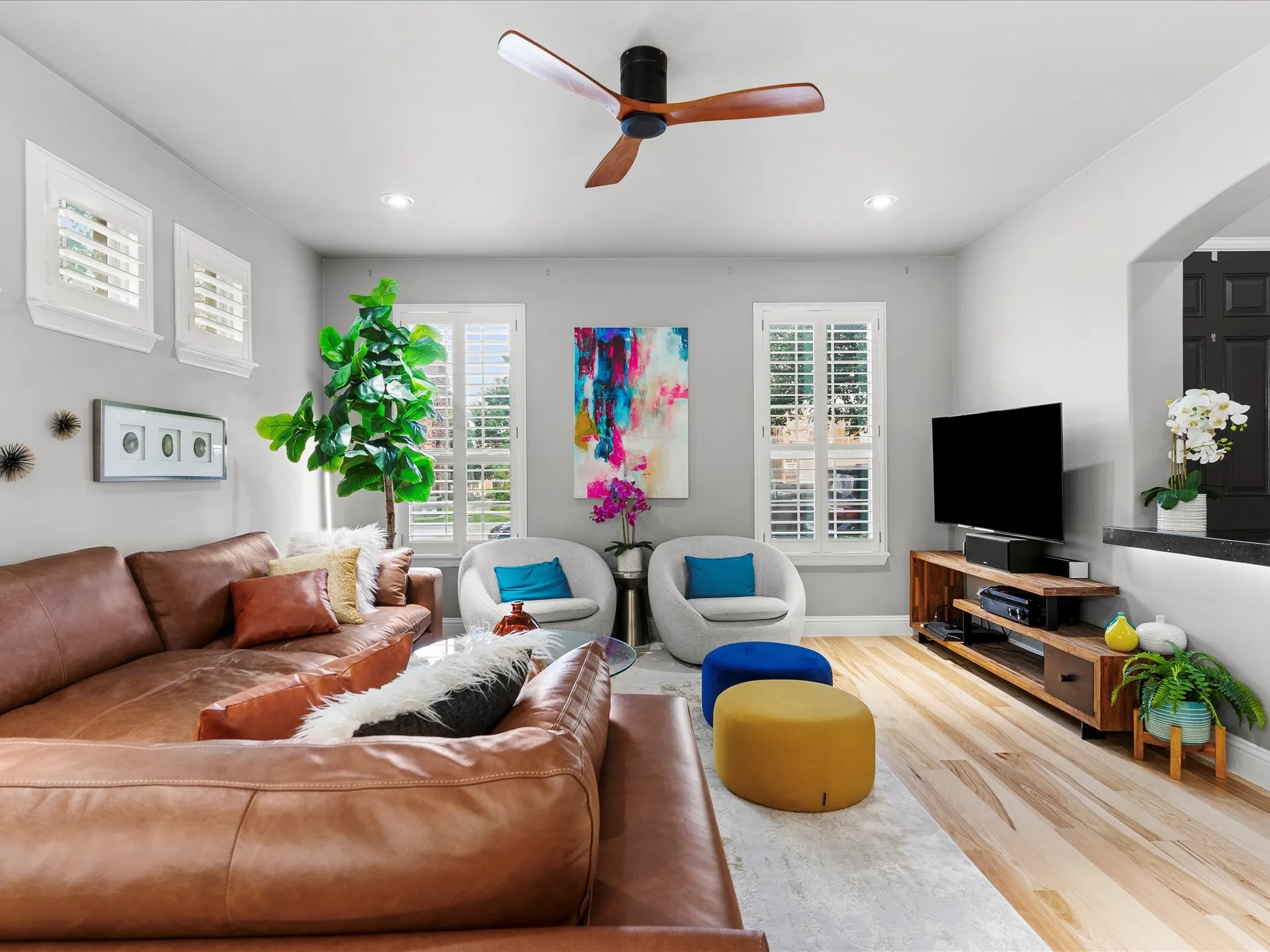 Living area featuring natural wood-finish flooring, recessed lighting, and a ceiling fan with wood-look blades