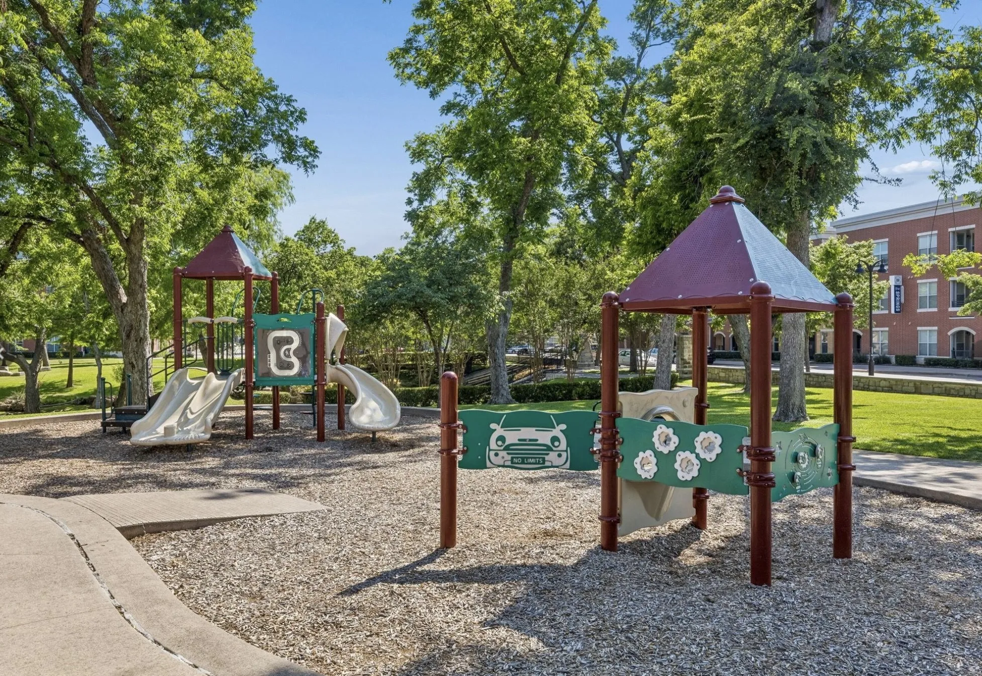 Outdoor play area featuring multiple slides, a climbing structure, and protective ground covering