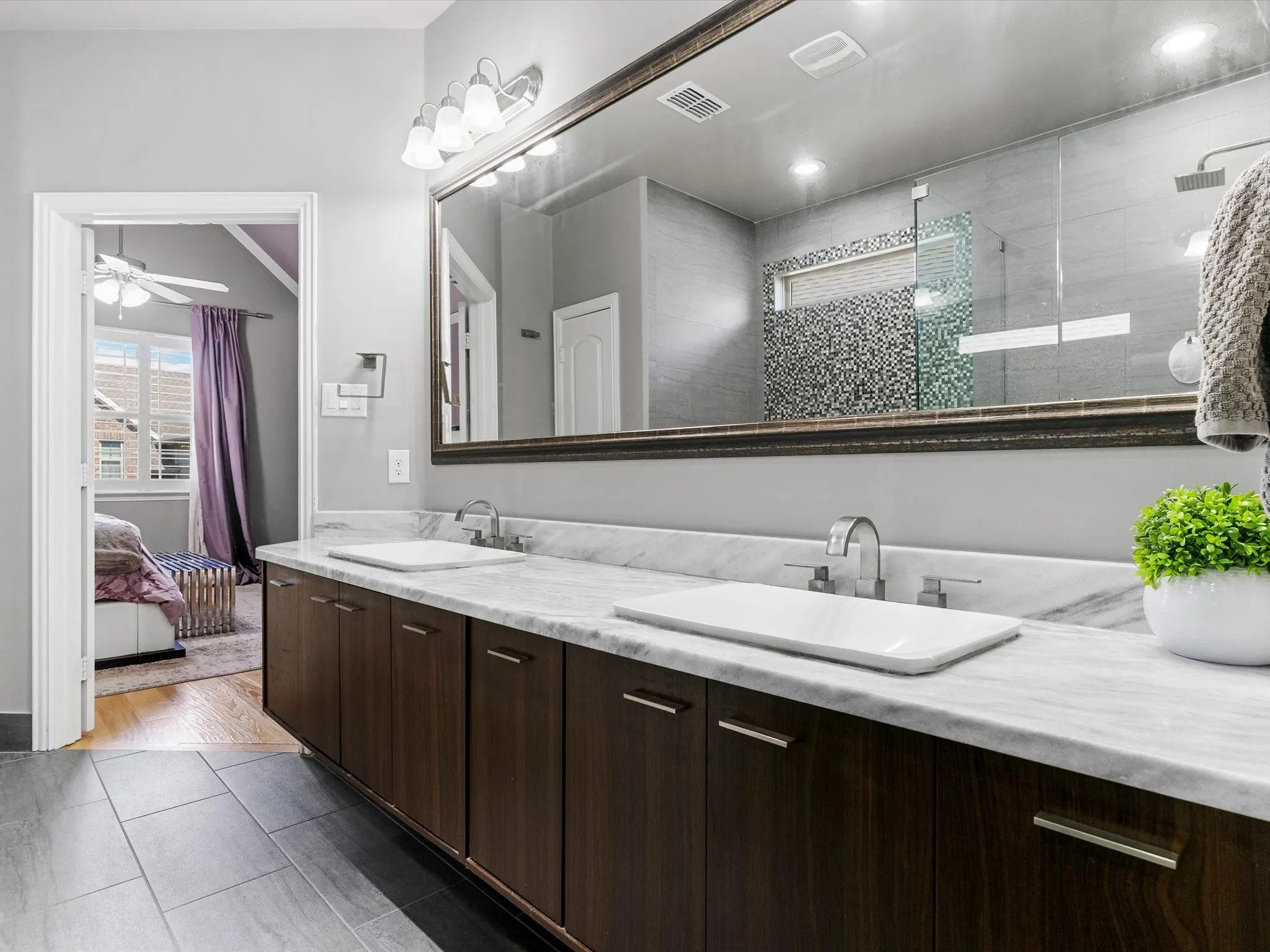 Double vanity with dark wood-finish cabinetry and white stone countertop
