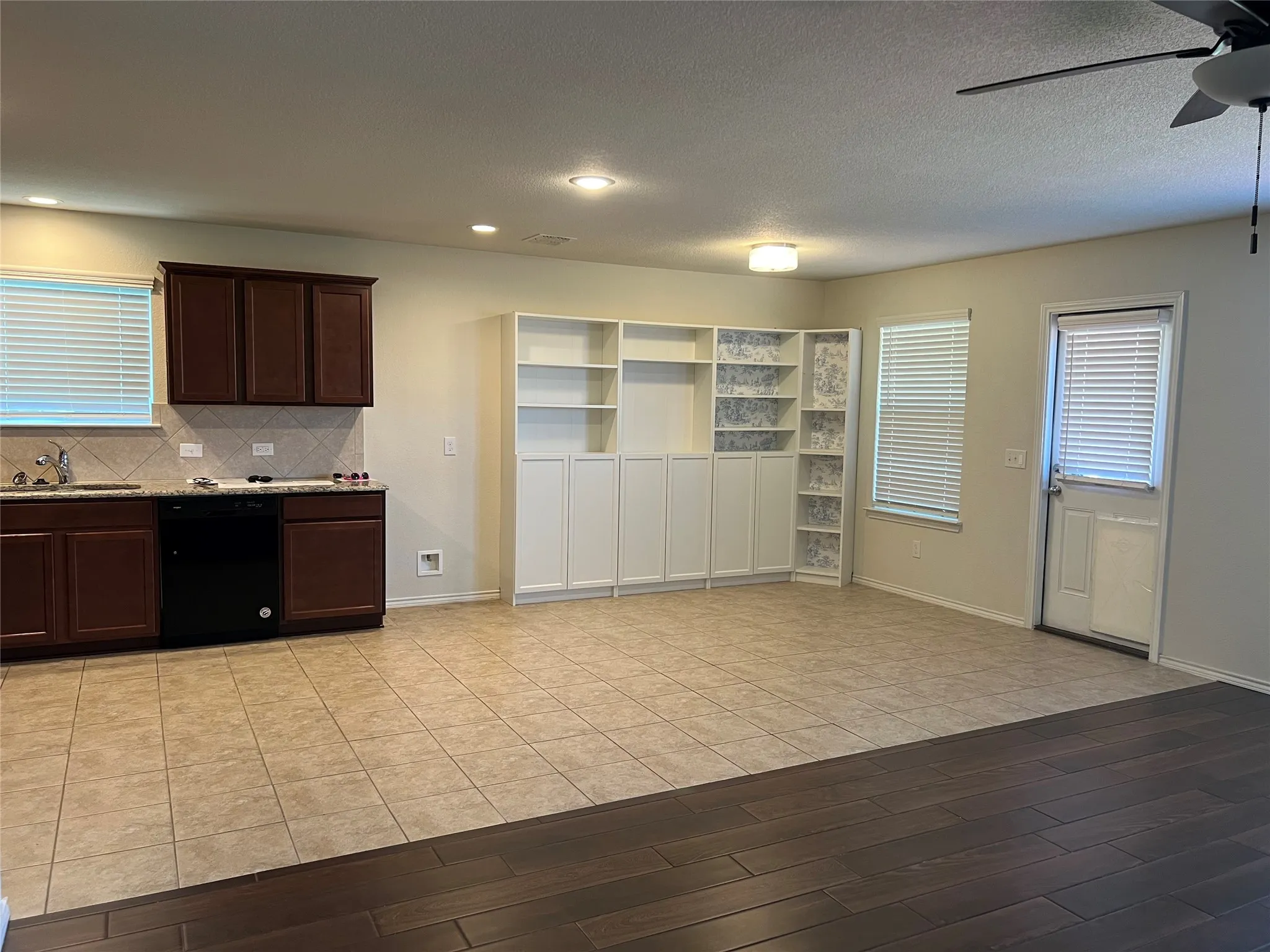 Tile floors in kitchen and dining areas.Additional white  shelving and cabinets in dining area.