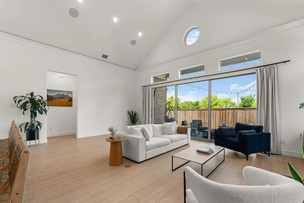Vaulted ceilings with recessed lighting and a circular transom window