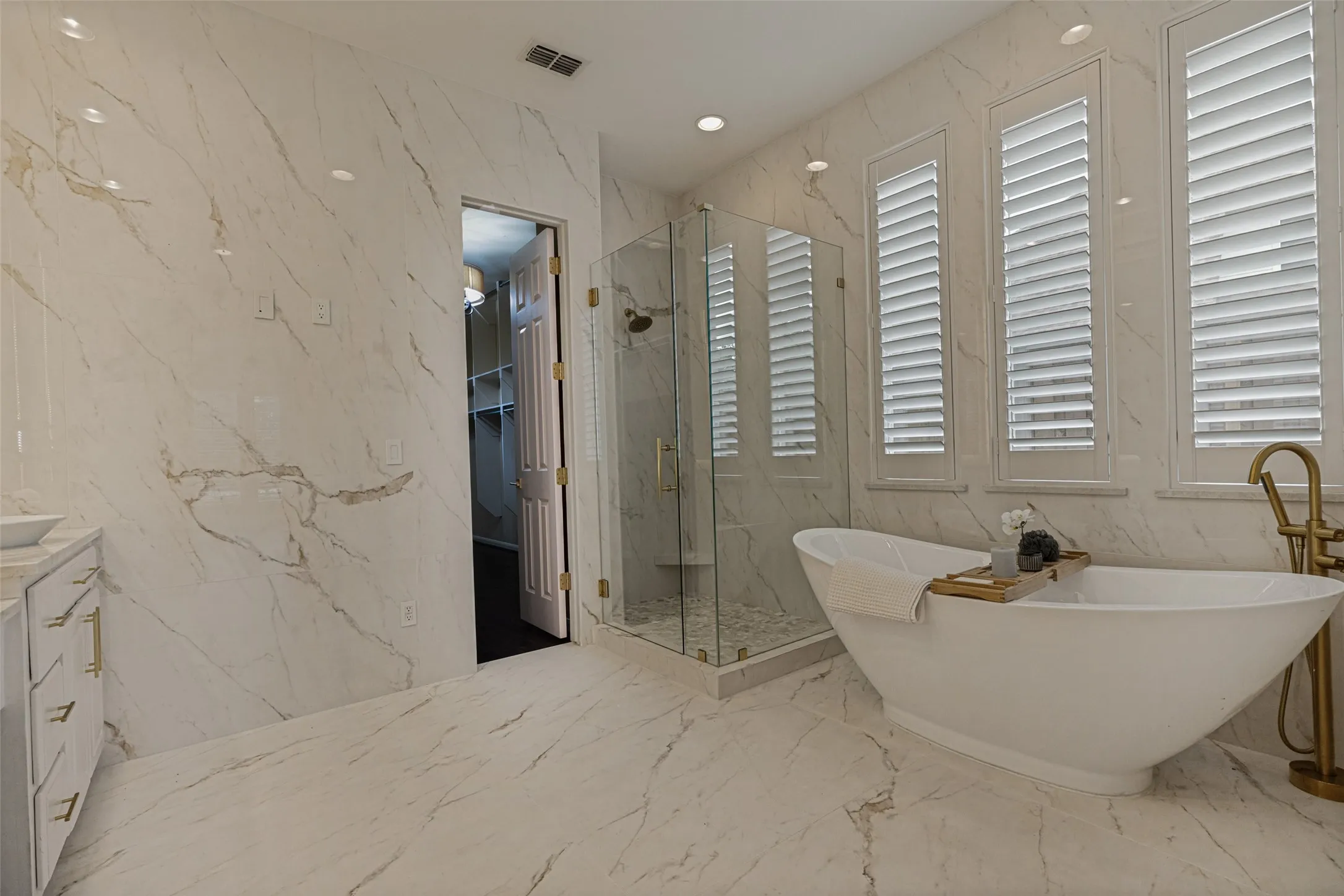 Whether you prefer a soaking bubble bath or a brisk shower, this luxury spa-inspired bath is available.  The freestanding oval slipper tub is ideal for a long relaxing soak, and the the adjacent shower is ready and waiting.  A door at this end of the bath opens to the closet.