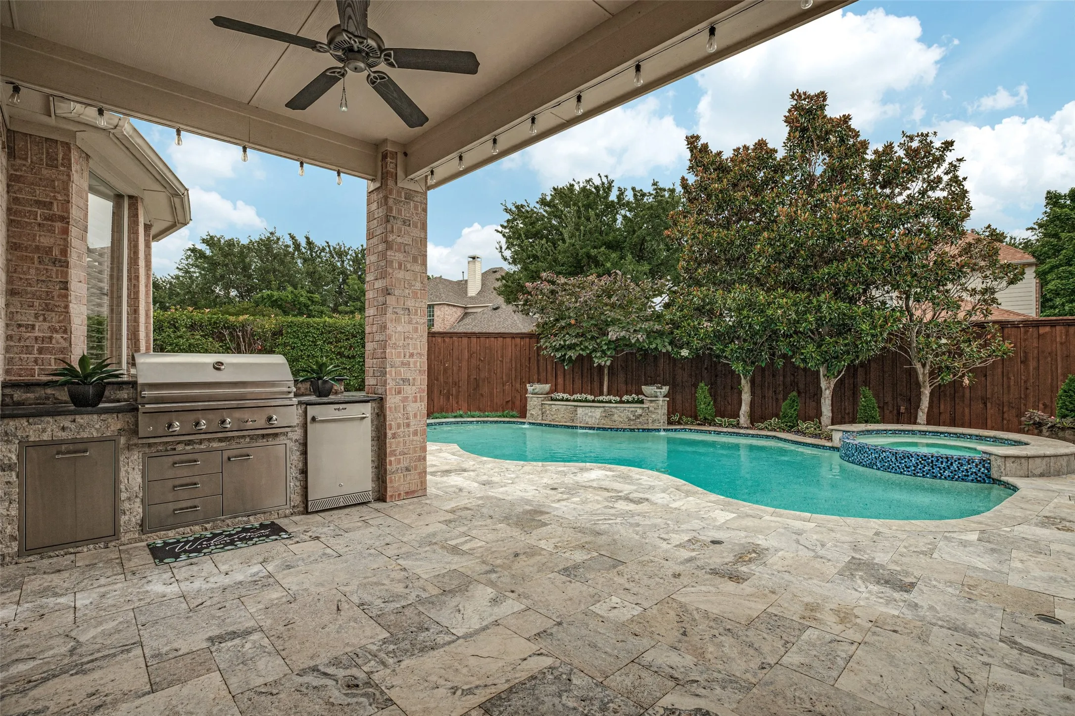 The spacious covered patio with two ceiling fans is a nice spot to sit in the shade and watch the activities around the pool.  There is room for a table and chairs or a nice seating area.  There is access to the patio from the garage which has recent paint on walls and floor.  A sink, workbench and three storage cabinets make this oversized garage very functional for the handy buyer or do-it-yourselfer.