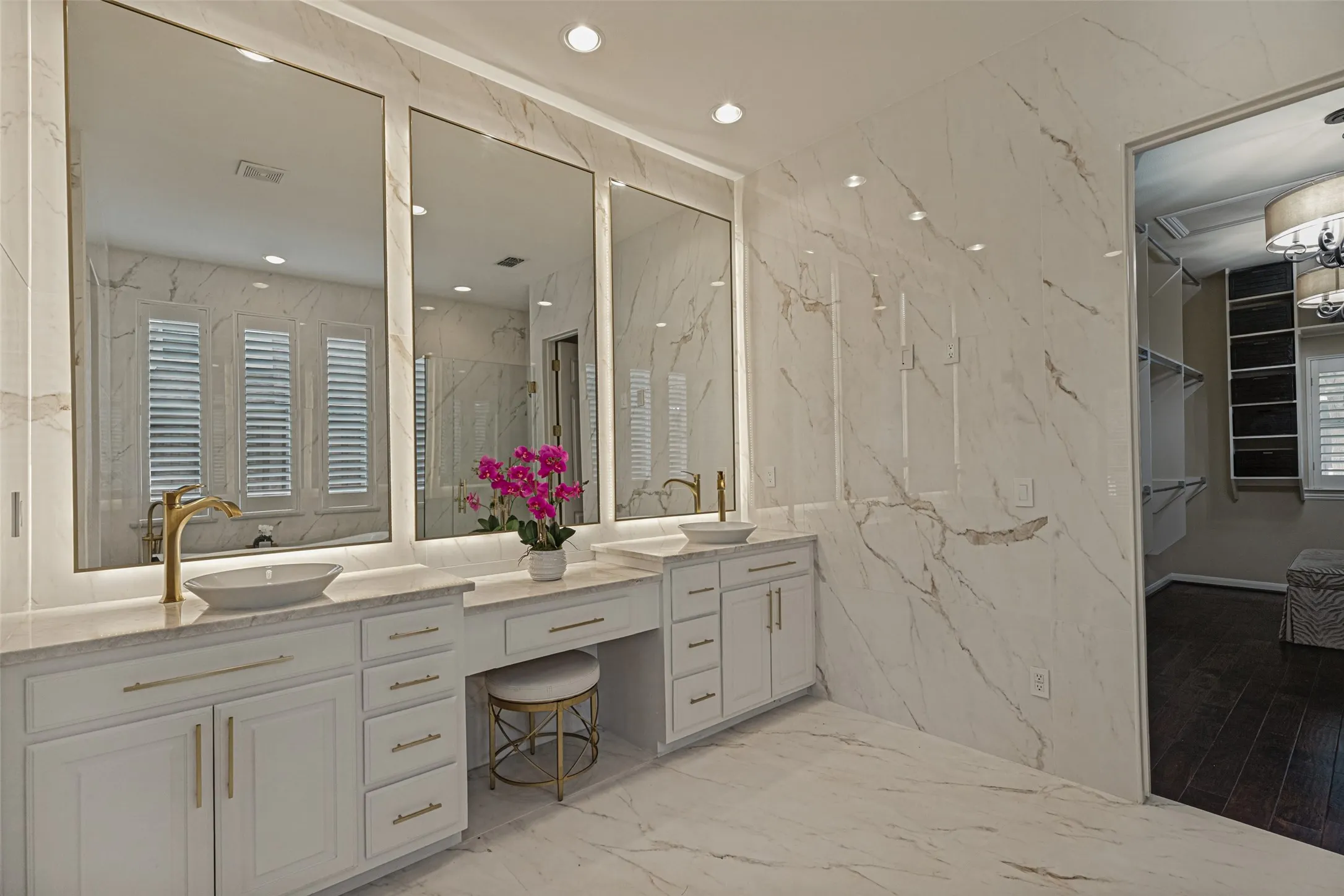 You will definitely say "WOW!" when you enter this amazing primary bath!  Totally remodeled from top to bottom, the words sleek, sophisticated and luxurious instantly come to mind.  Large format porcelain tiles with a marble design line walls from floor to ceiling, surround the shower and cover the floor.  A wide white painted vanity includes plenty of storage and a convenient knee space for sitting.