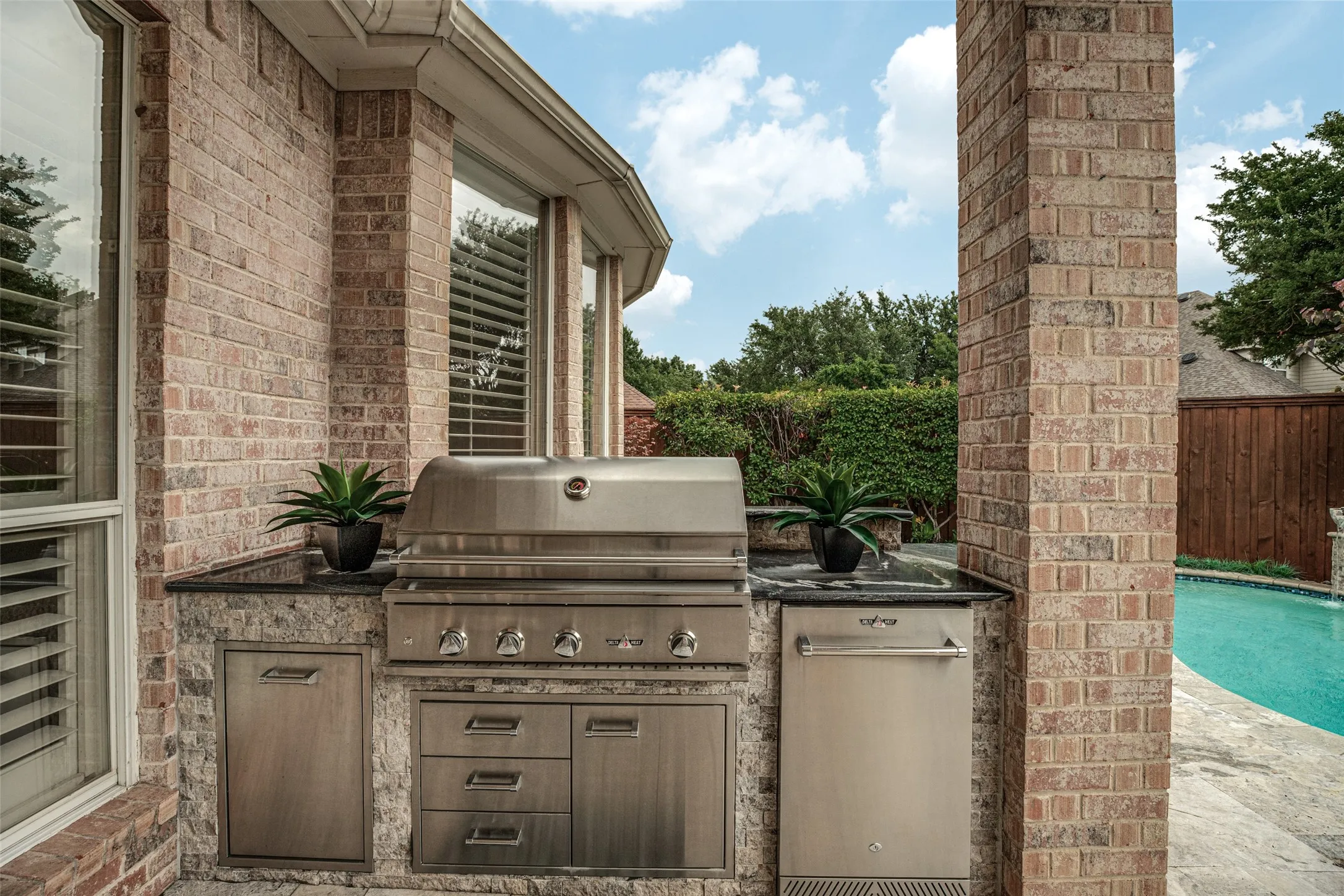 Fire up the grill and invite the gang for an afternoon of fun!  Grill masters will love having this built-in grill with an oversized gas grill, refrigerator, storage drawers and trash bin.  Marble countertops provide space for prepping and serving.  A gas stub is also available in the patio area should it be needed for additional features.  Stacked silver travertine, matching the decking frames the outdoor equipment.