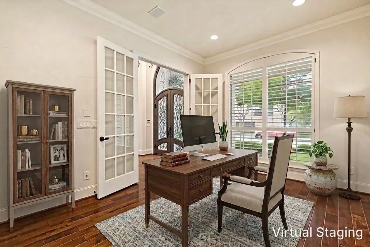 Across the entry is a lovely study.  Wood floors flow into this room and crown molding and recessed lights are above.  Working at home will be a pleasure in this delightful room with views of the front of the home through a pair of arched windows with shutters.  French doors are available for privacy or a quiet workspace.  The room was virtually staged to give buyers a suggestion of how furniture might fit in the room.