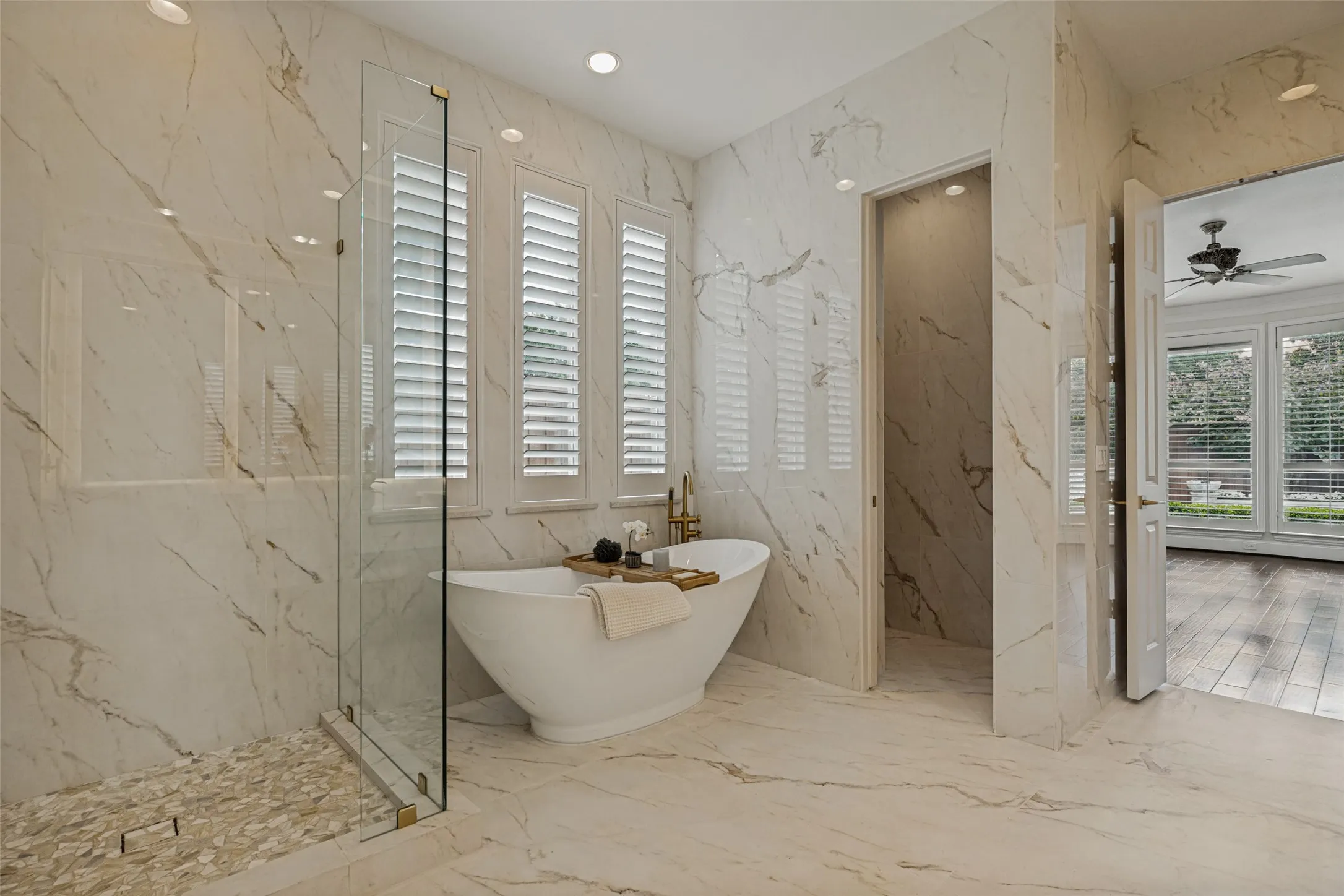 Three windows above the tub supply natural light to the bath, and recessed lights above add even more light.  The shower has a dropped pan with a stone mosaic floor.  Frameless glass encloses the shower.  This gorgeous bath is fit for a celebrity!