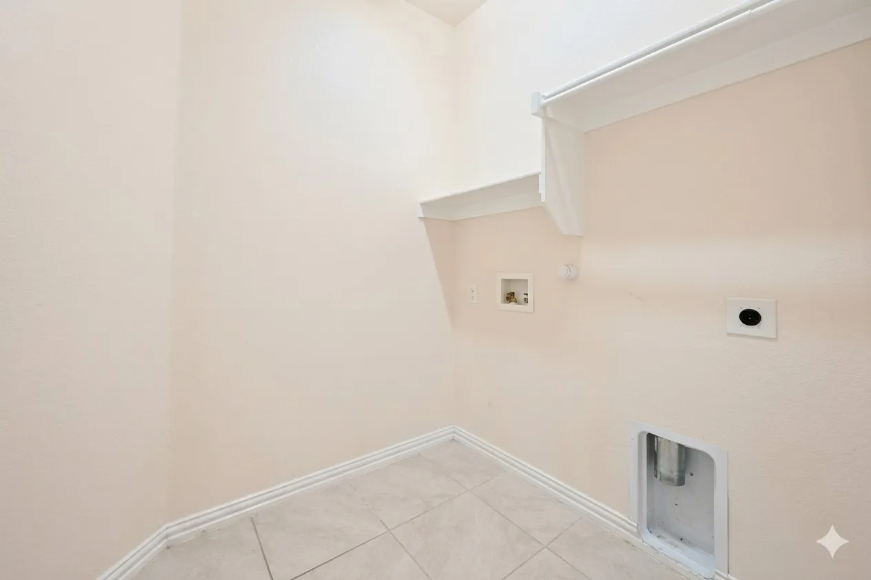 Utility room featuring a tiled floor, light-colored walls, and a built-in shelf