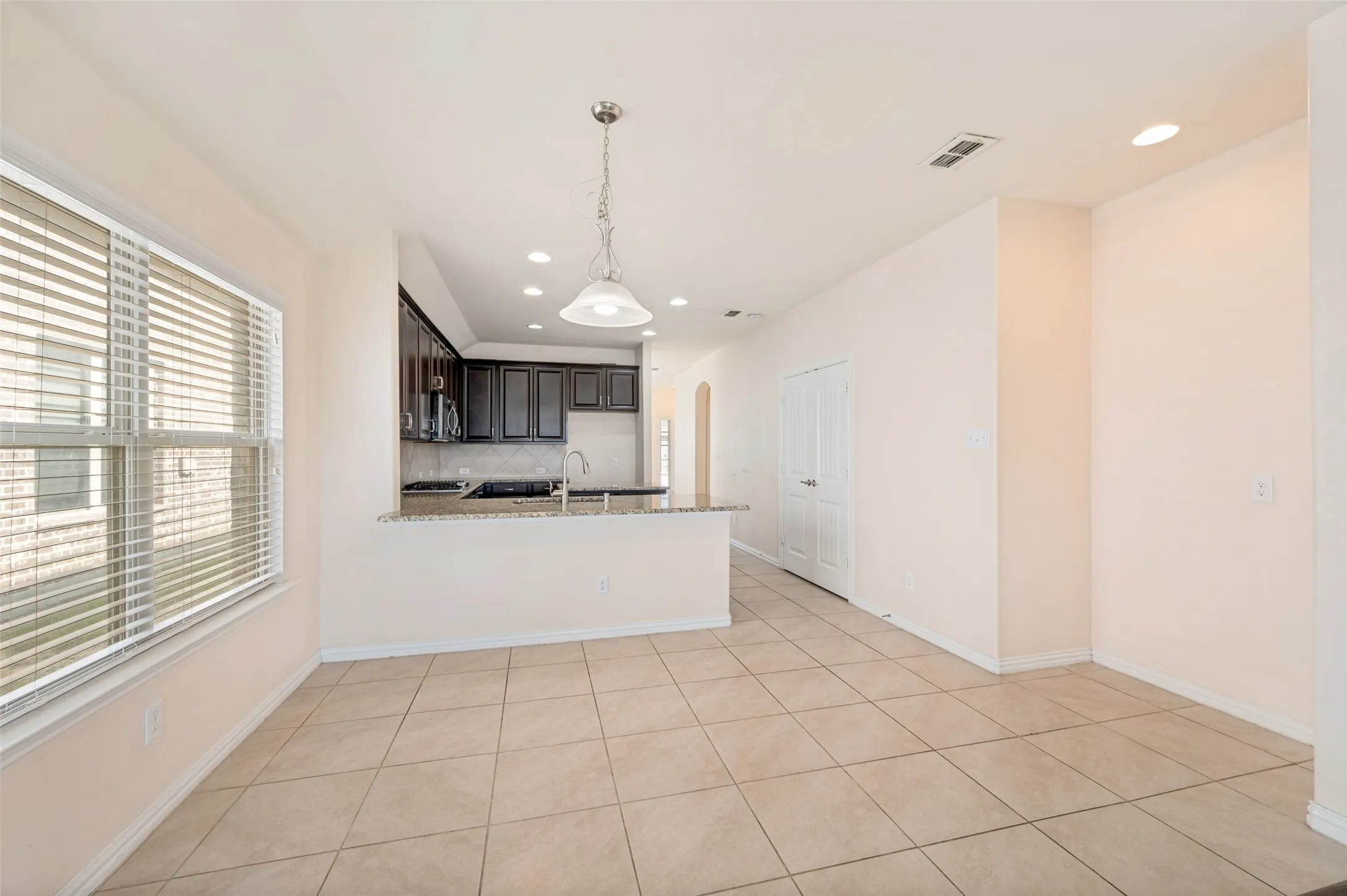 Open-concept living area with neutral tile flooring