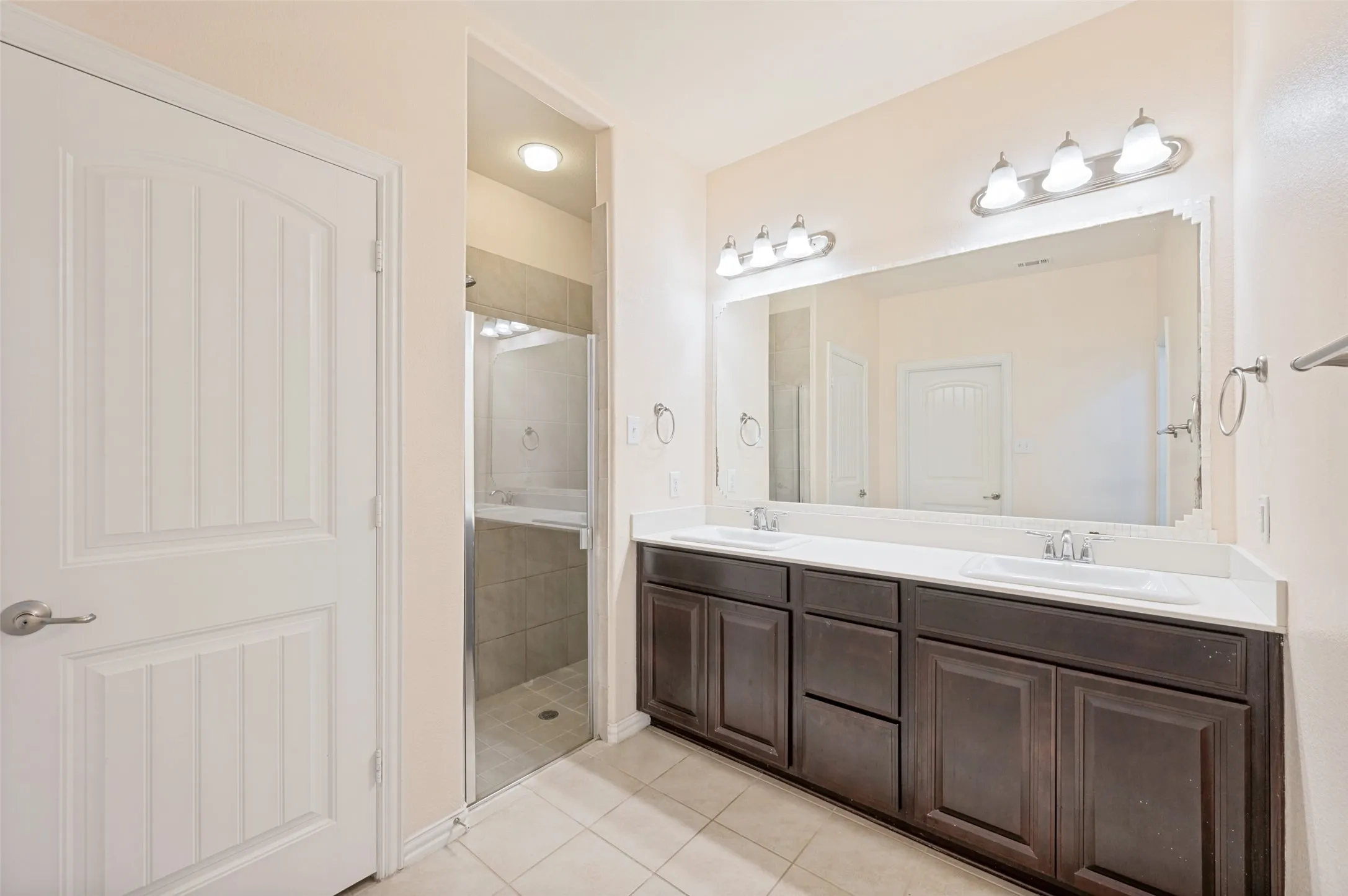 Master bathroom Dual vanity with white undermount sinks and dark wood-finish cabinetry