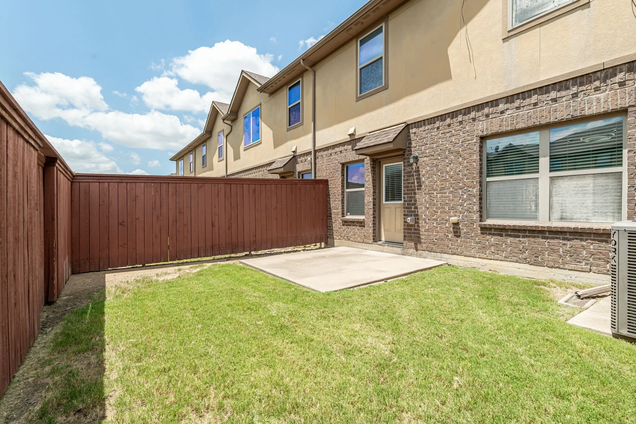 Backyard view with HOA-maintained lawn and fenced space.