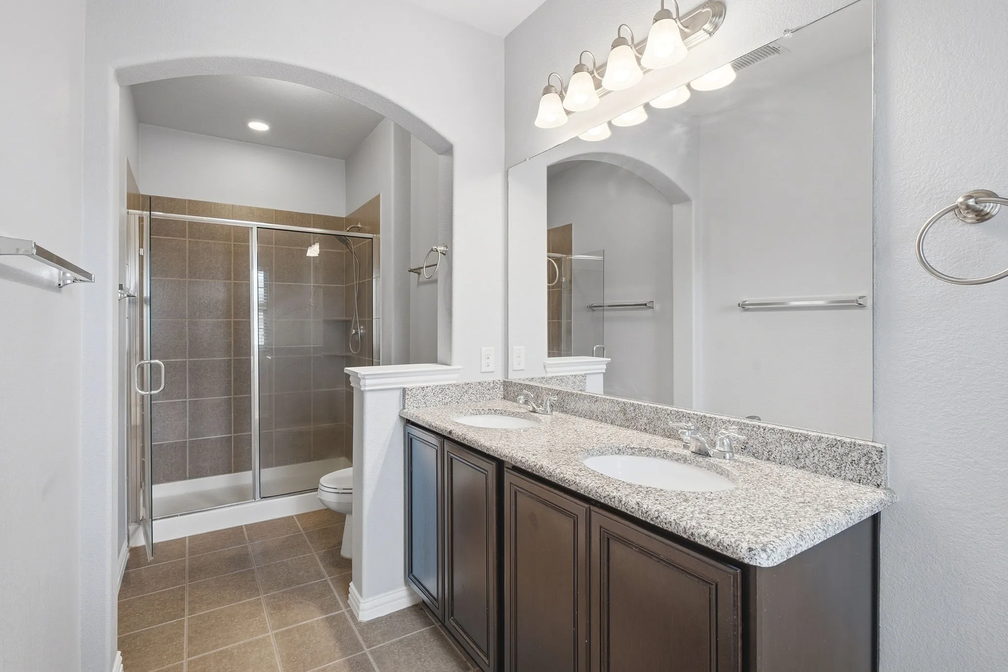 Primary bathroom with dual-sink vanity and walk-in shower.