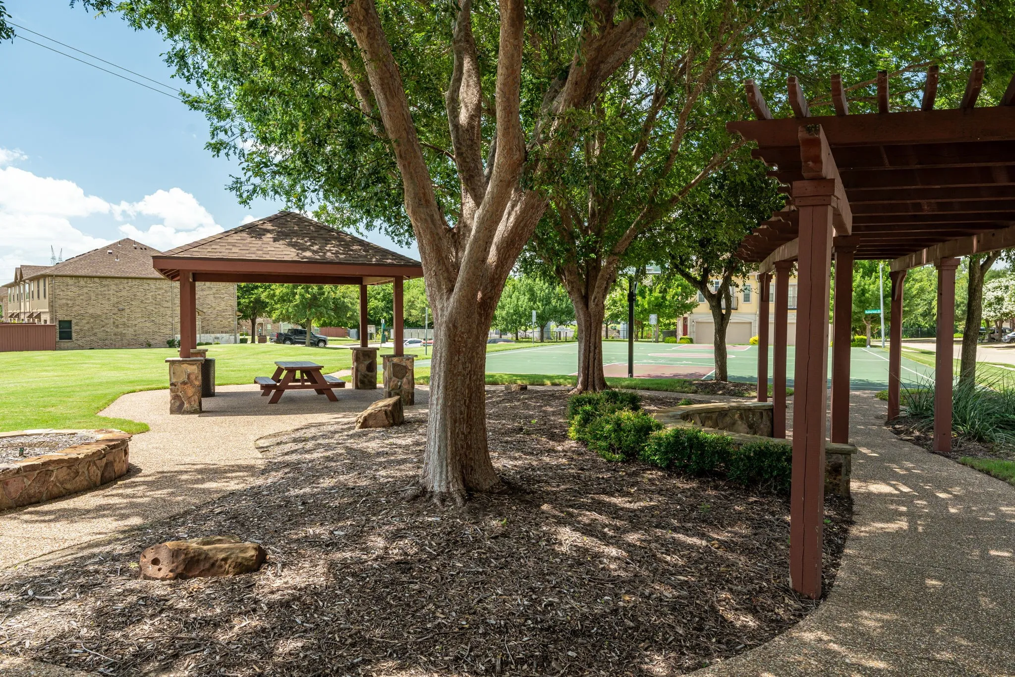 Neighborhood green space with gazebo and walking trail near the basketball court.