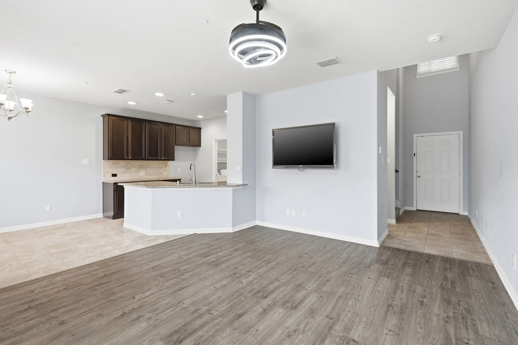 Main floor view with kitchen, front door, and dining area.