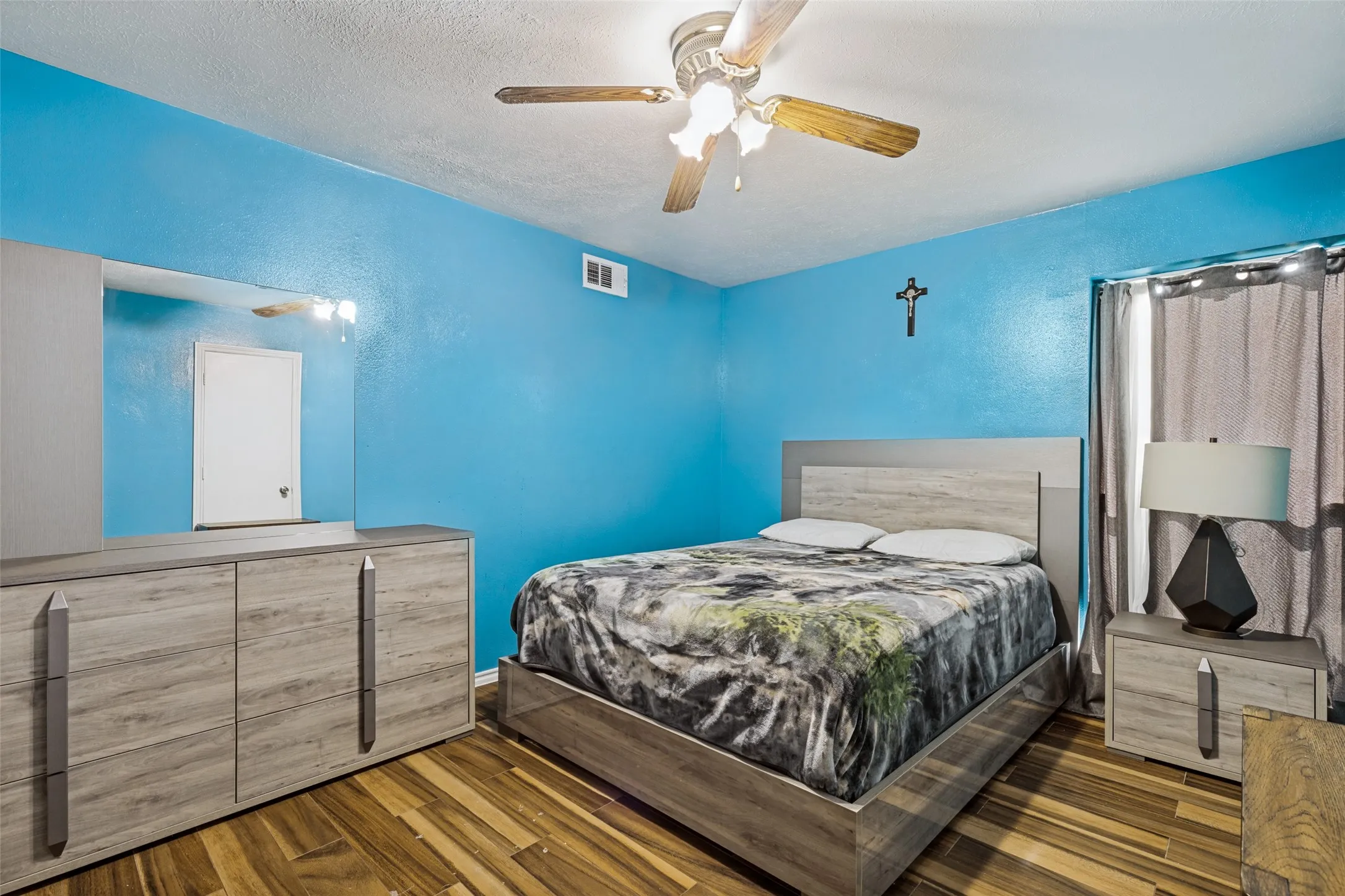 Room featuring wood-finish flooring and a ceiling fan with light fixture