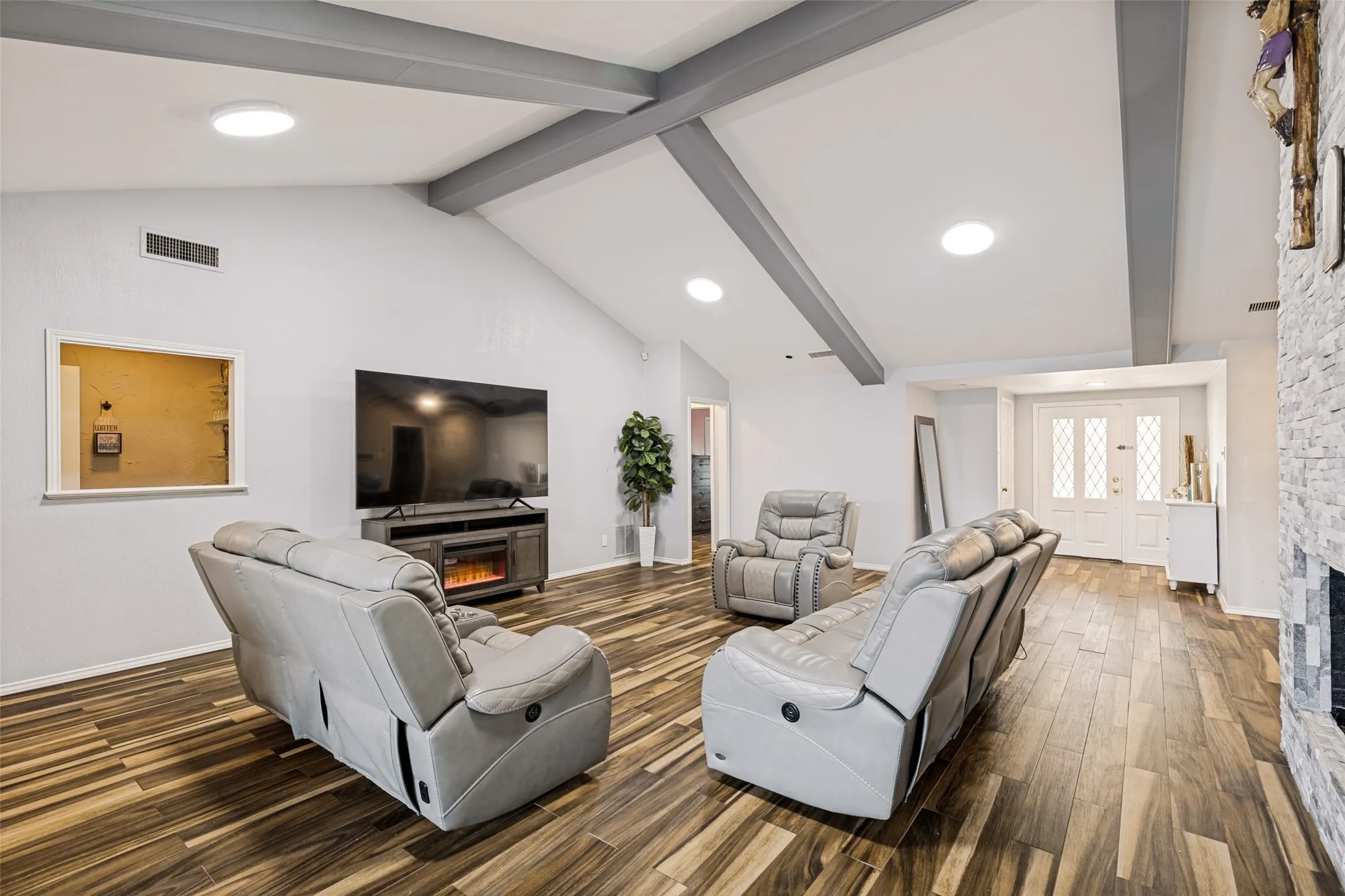 Vaulted ceilings with exposed beams complement the wood-finish flooring