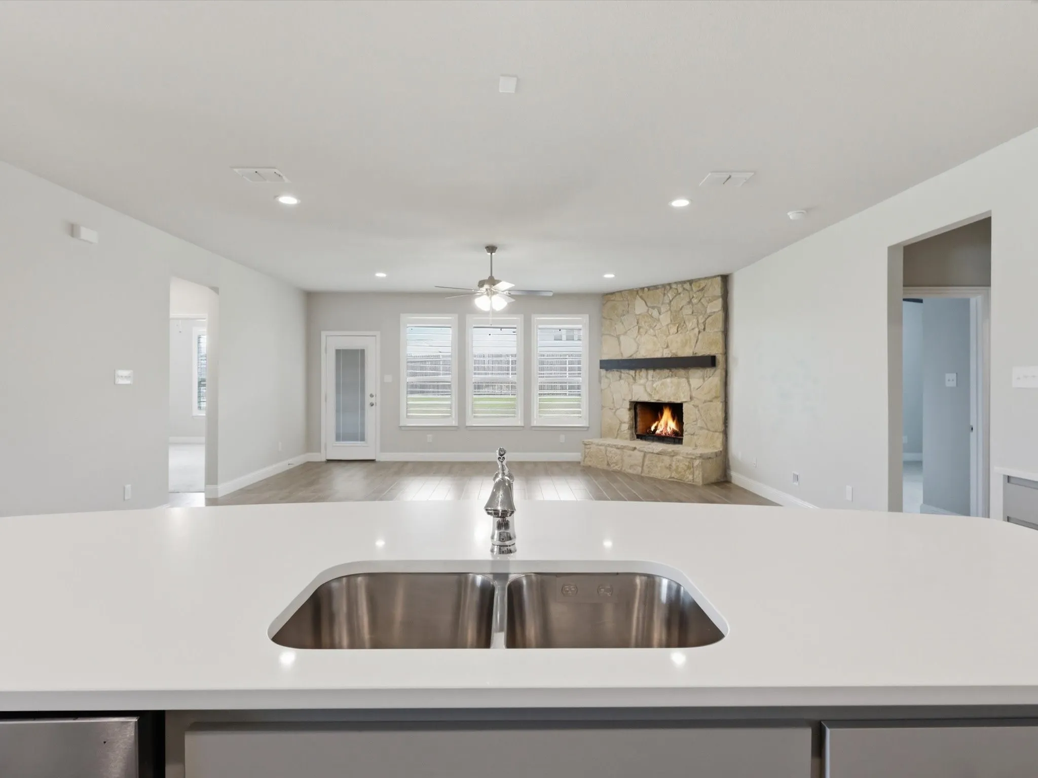 Kitchen island featuring a stainless steel sink and a contemporary faucet, complemented by light-toned countertops