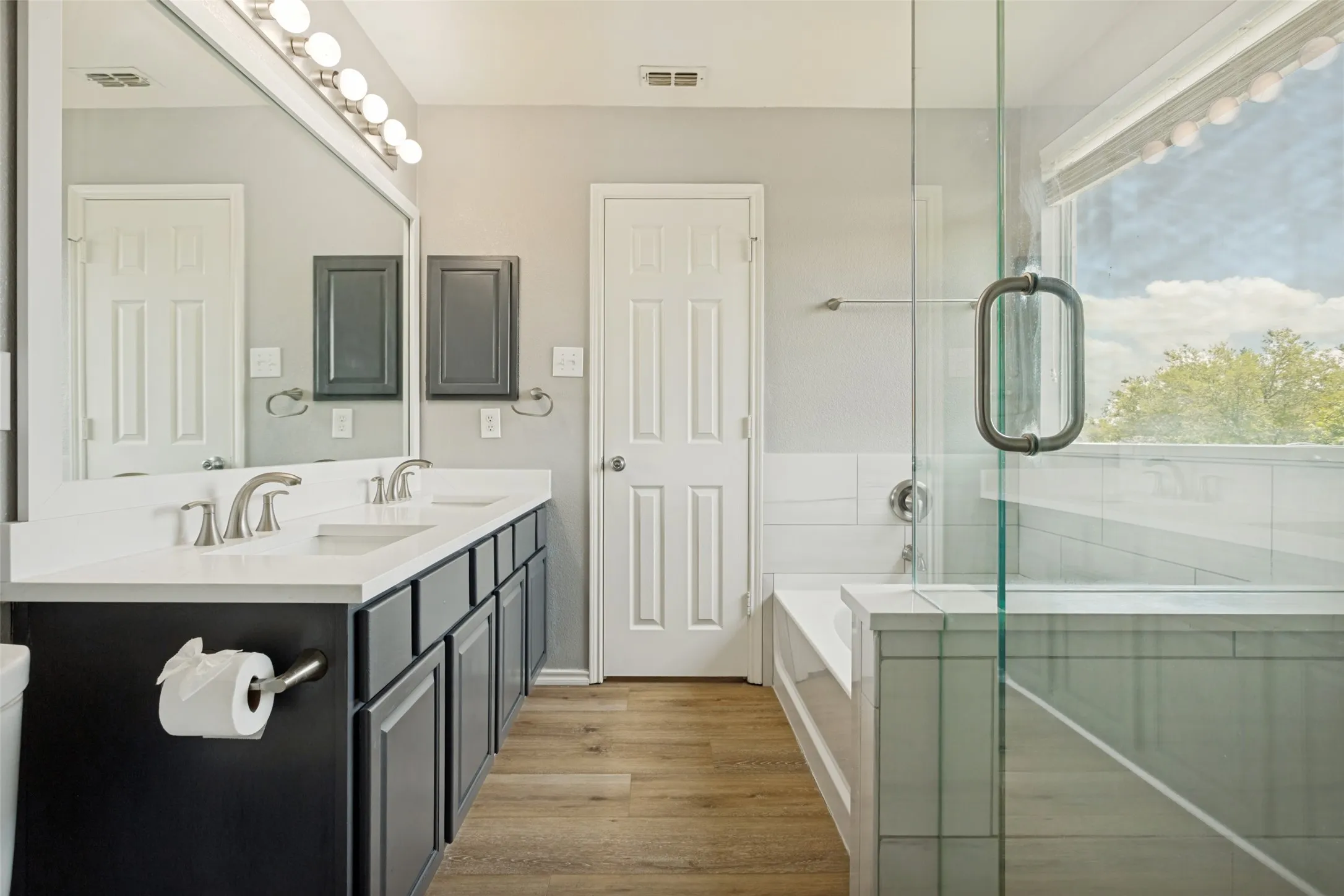 Bathroom featuring a dual vanity with white countertops, undermount sinks, and brushed nickel faucets