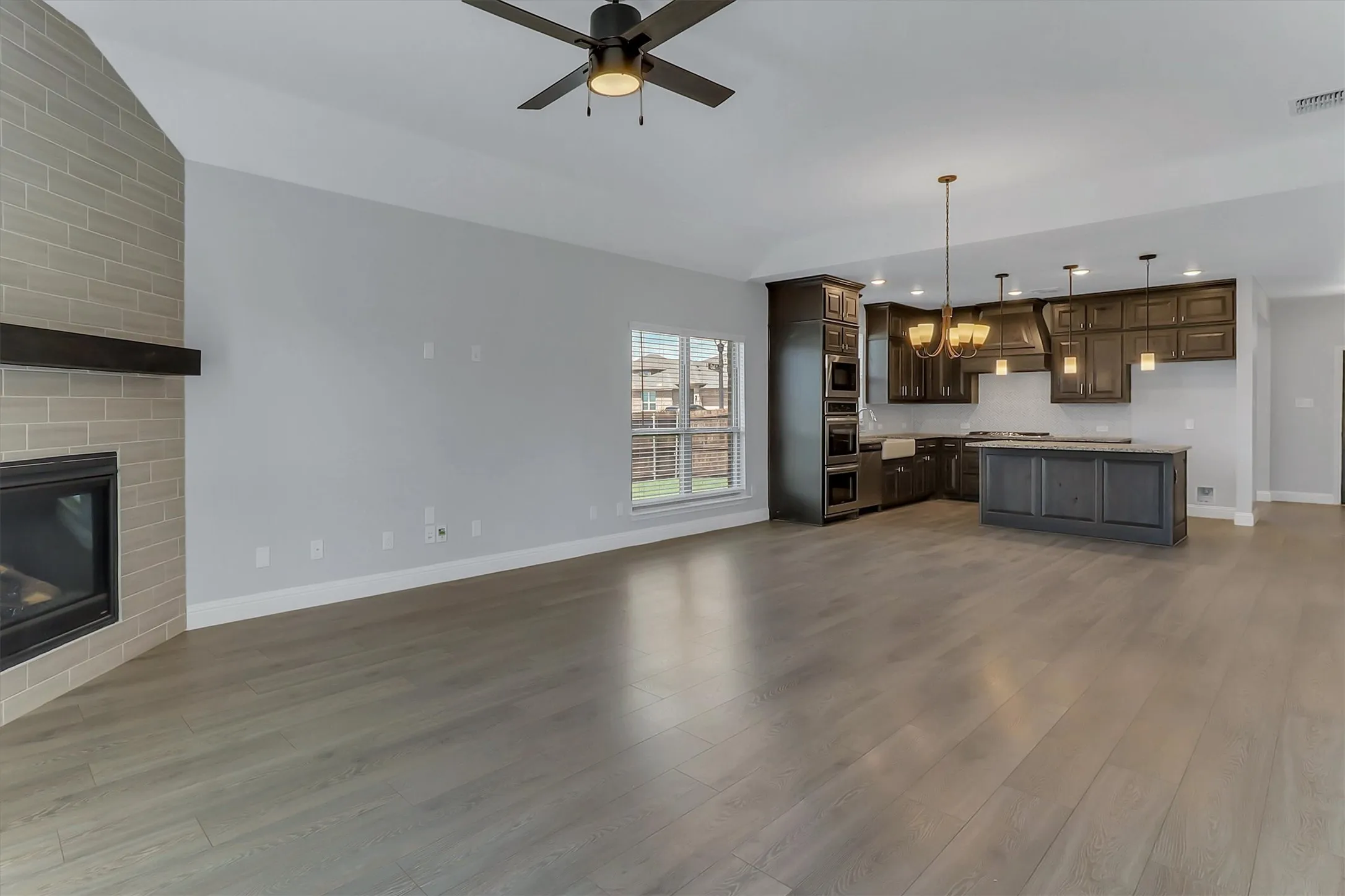Spacious open-concept living area featuring light wood-finish flooring
