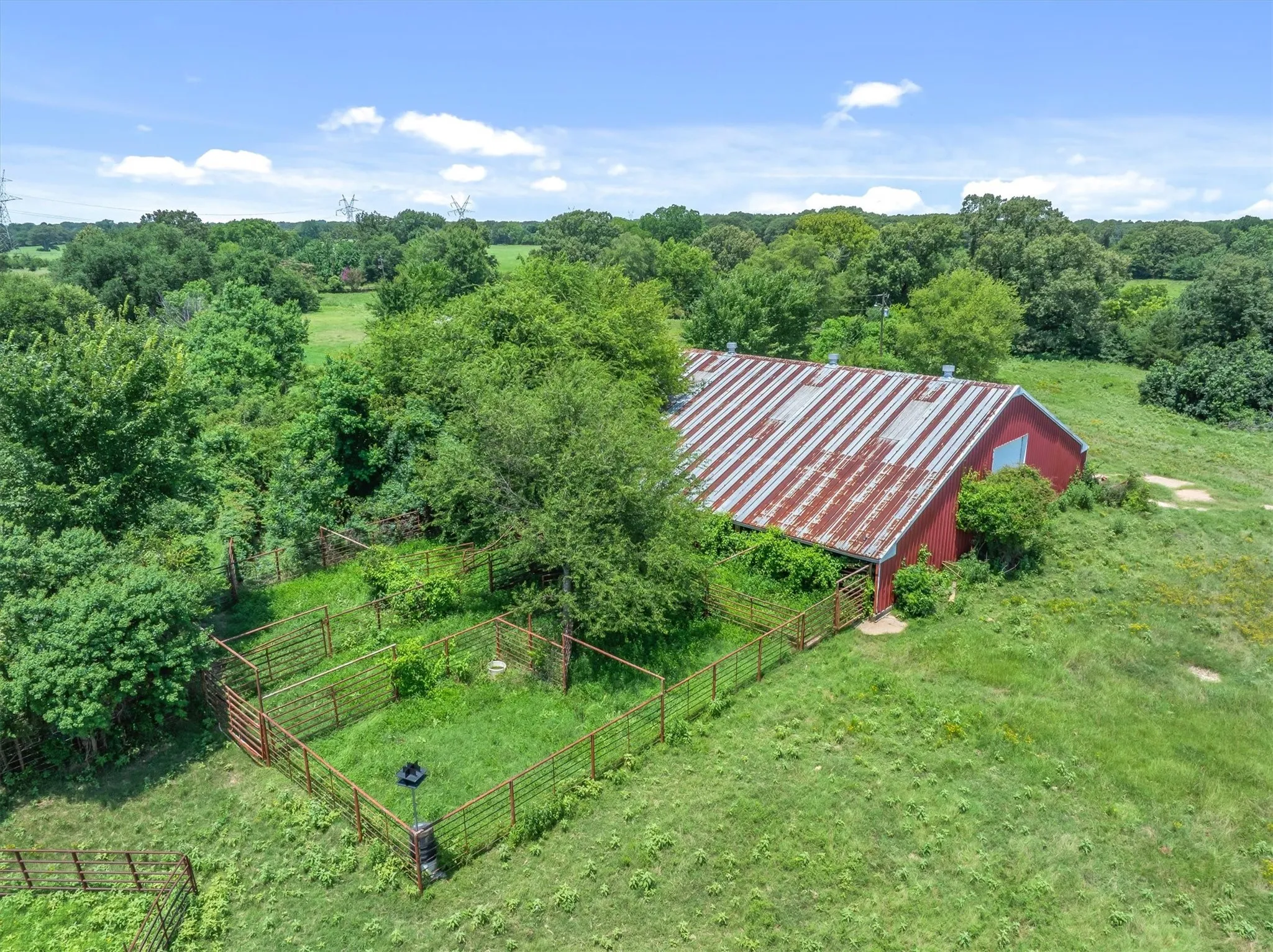 Red barn structure featuring a corrugated metal roof and a single window
