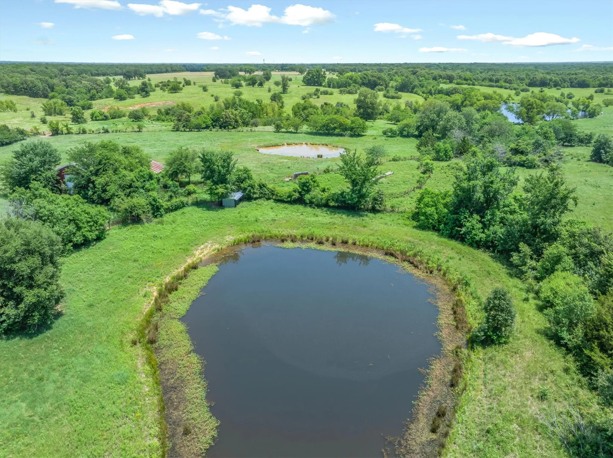 Expansive green acreage featuring multiple ponds and scattered mature trees