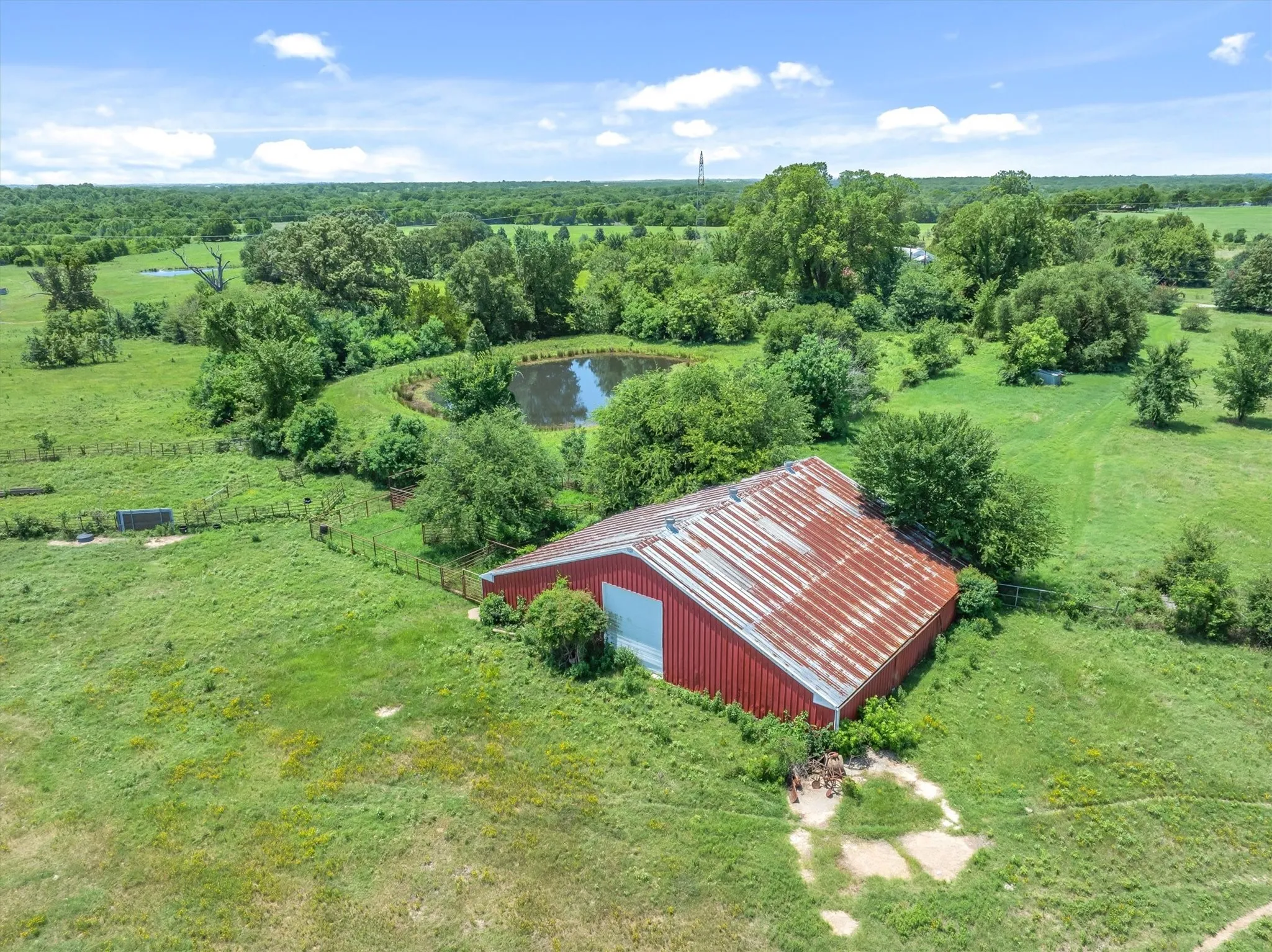 Red-sided barn with a corrugated metal roof