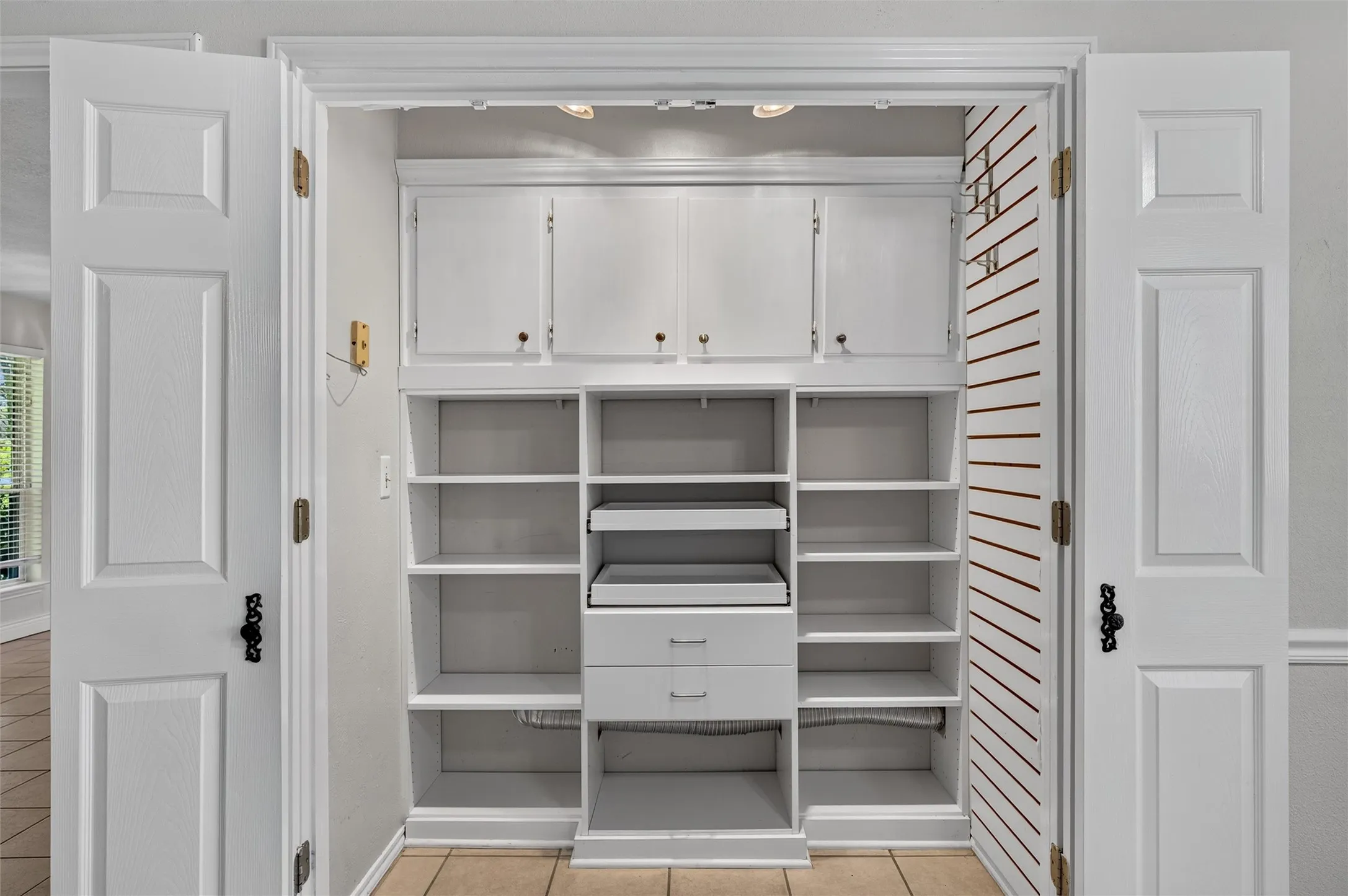Spacious pantry with pull out drawers and shelves plus a cabinet pantry next to fridge