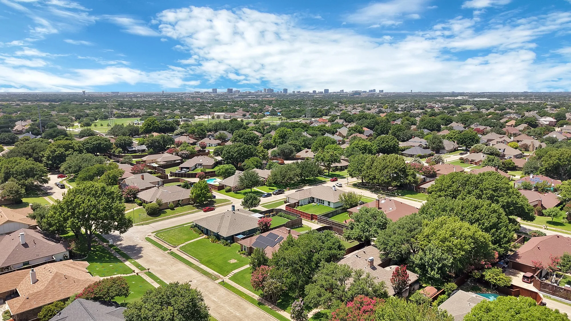 Expansive residential area featuring numerous detached homes with varied rooflines and mature tree coverage